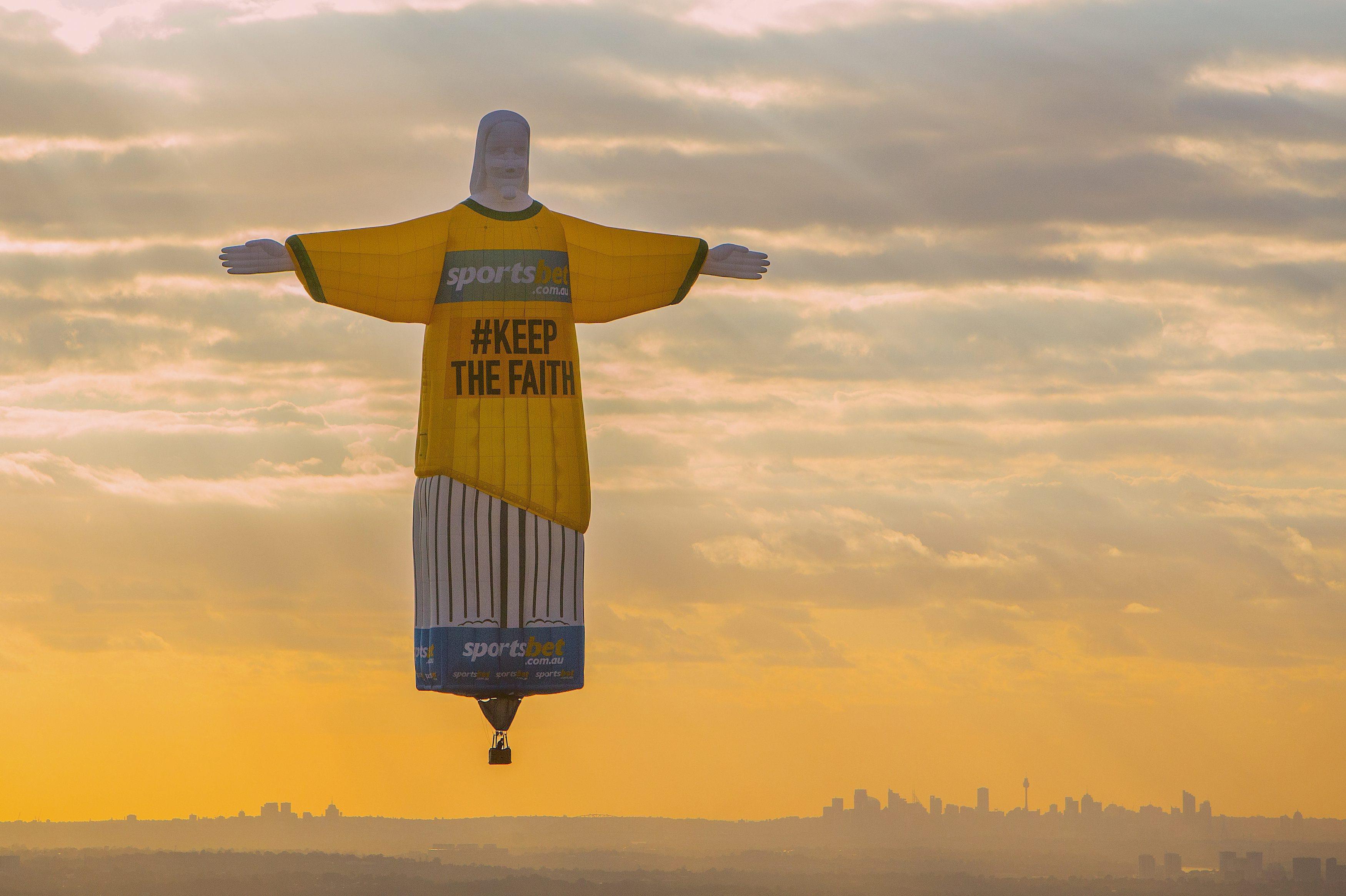 A balloon shaped in the famous 'Christ the Redeemer' statue floats at sunrise as part of an advertis