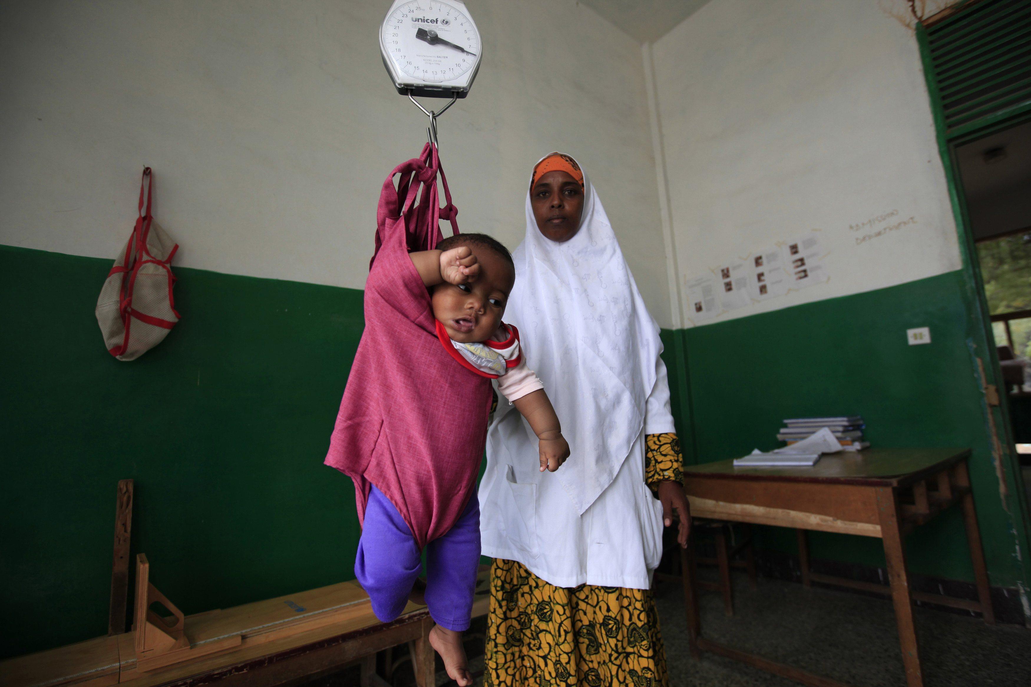 An internally displaced child is weighed at Banadir Hospital in Mogadishu September 28, 2013. Street
