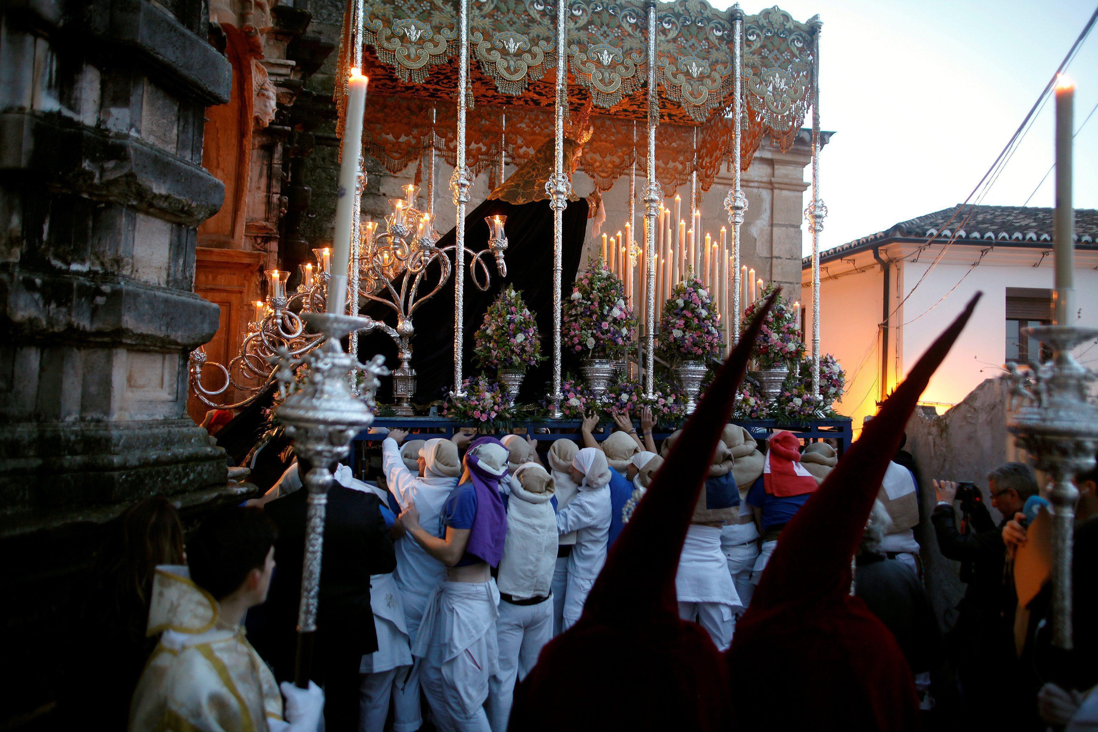 Costaleros leave a church as they take part in a procession during the Holy Week in Ronda