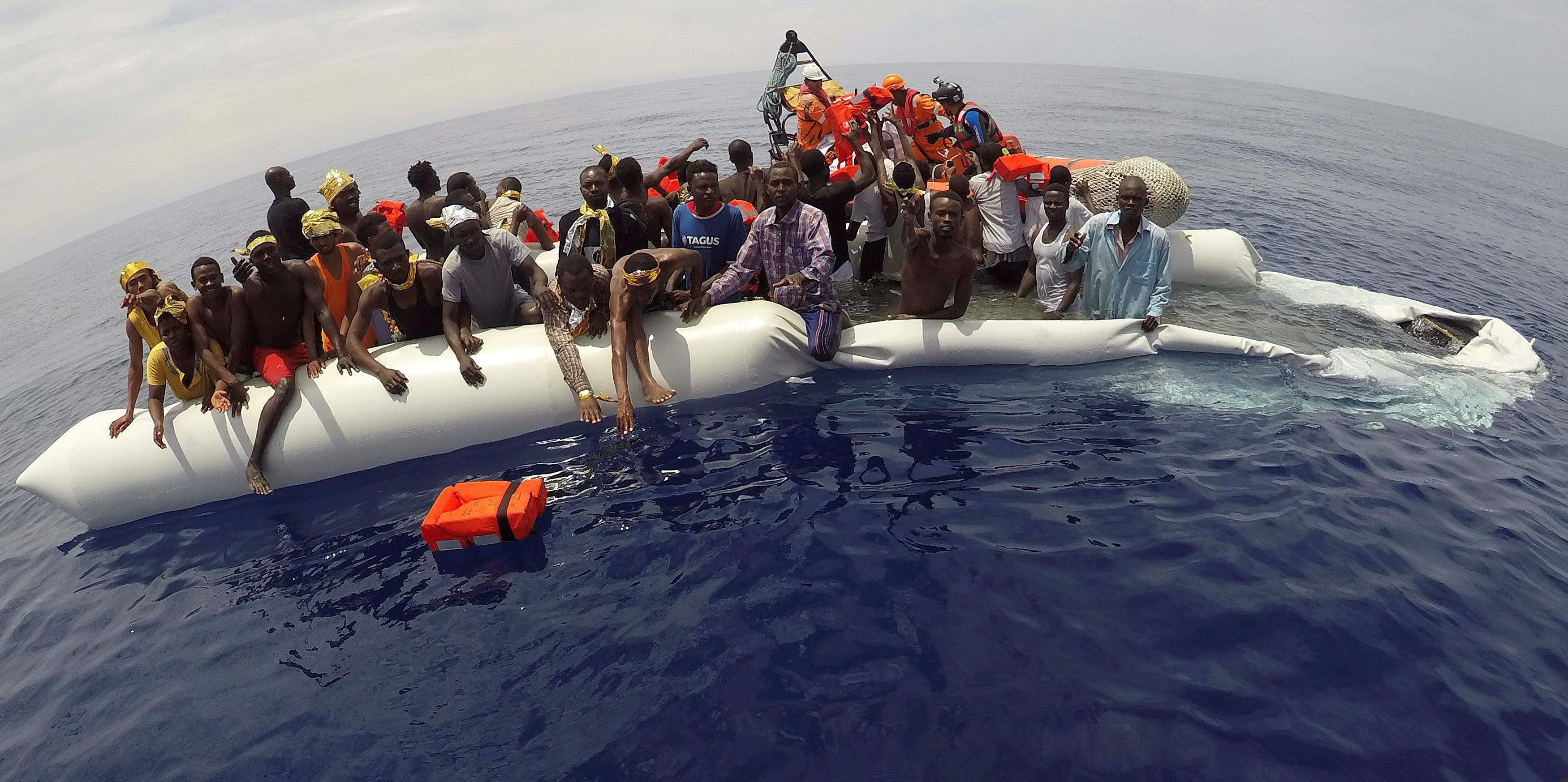 FILE PHOTO: Migrants on a dinghy are rescued by 