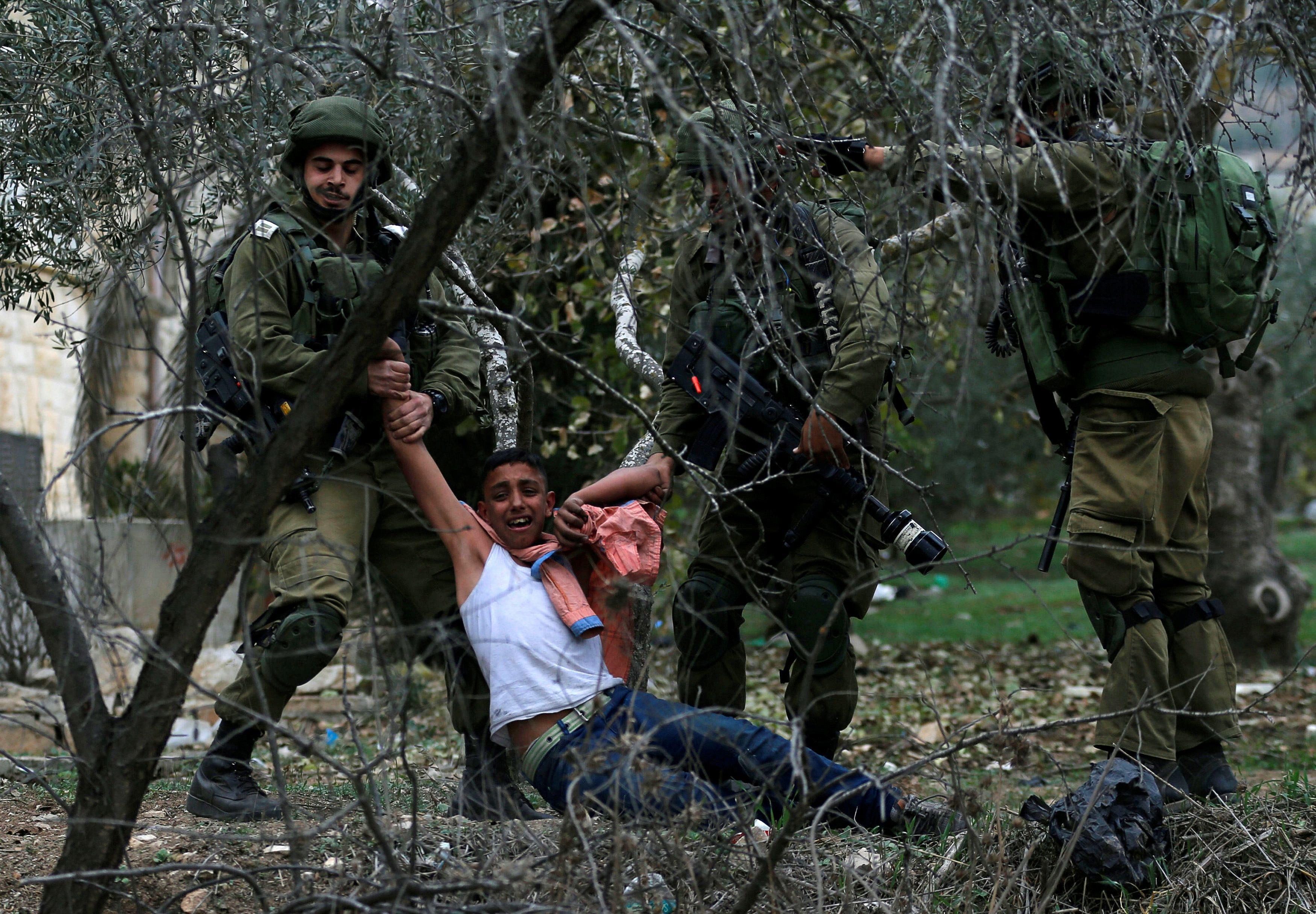 Israeli soldiers detain a Palestinian during clashes at a protest near the West Bank city of Nablus