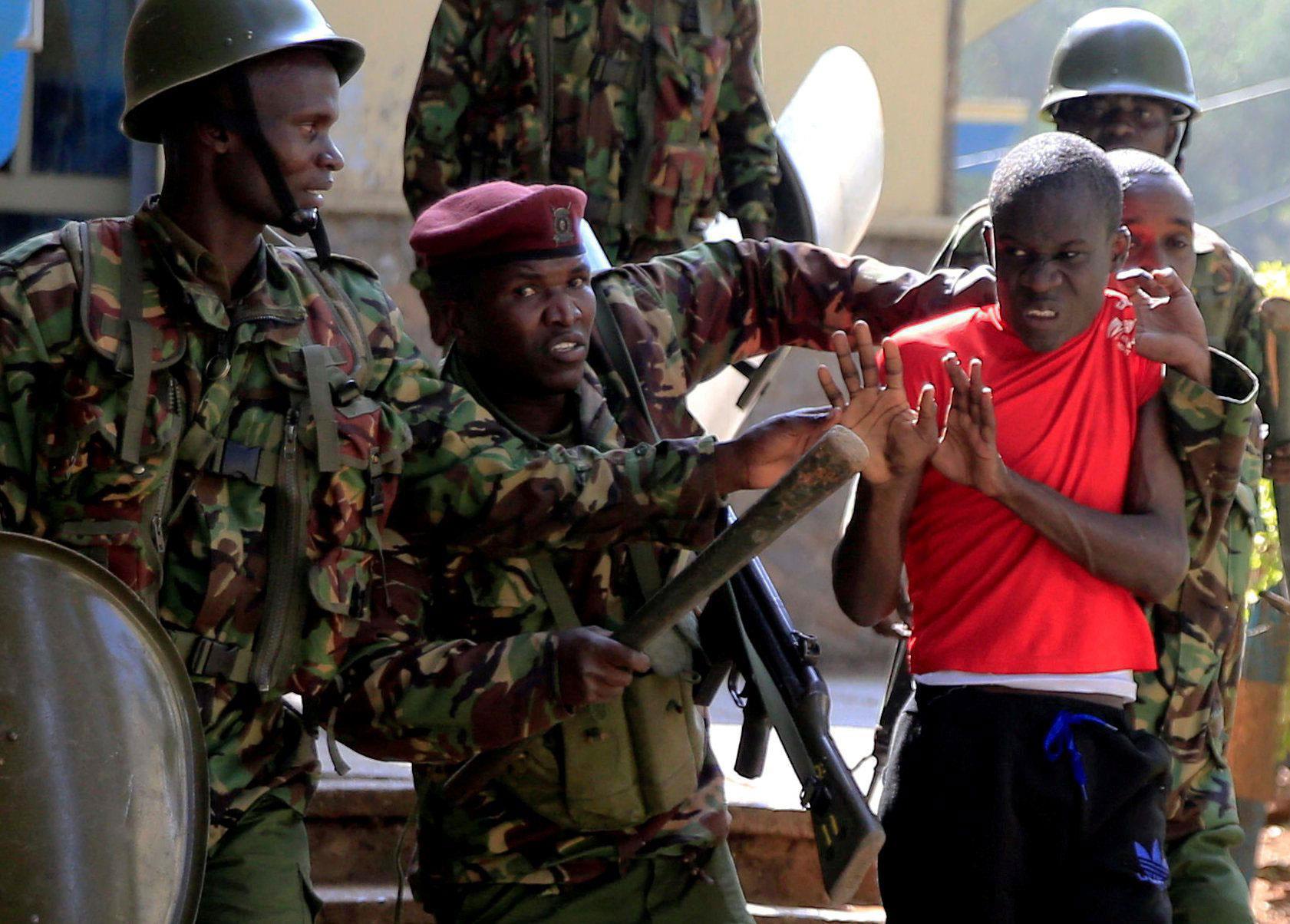 Riot policemen arrest a student of University of Nairobi after the protests against the detention of