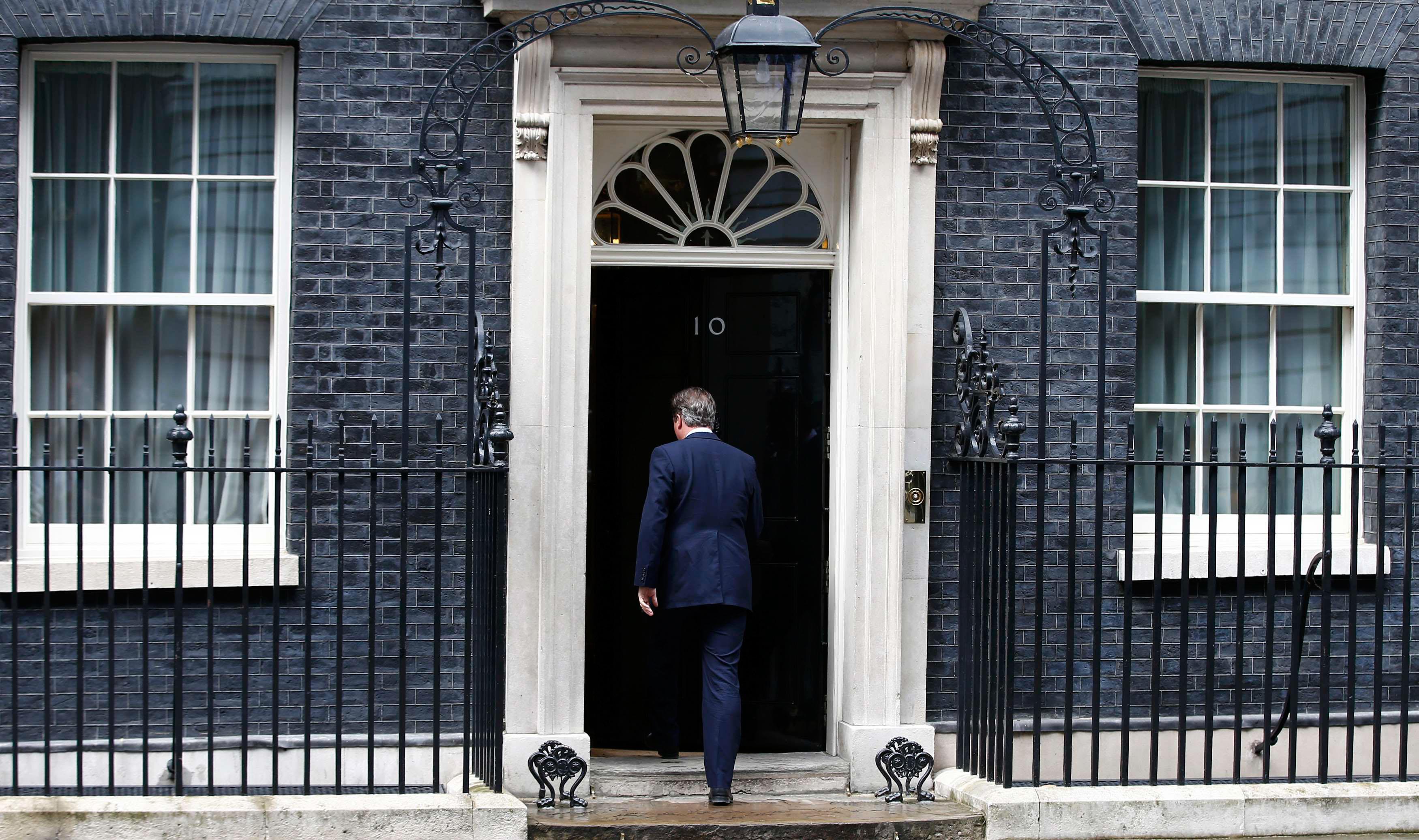 Britain's Prime Minister David Cameron returns to 10 Downing Street after making a statement in West