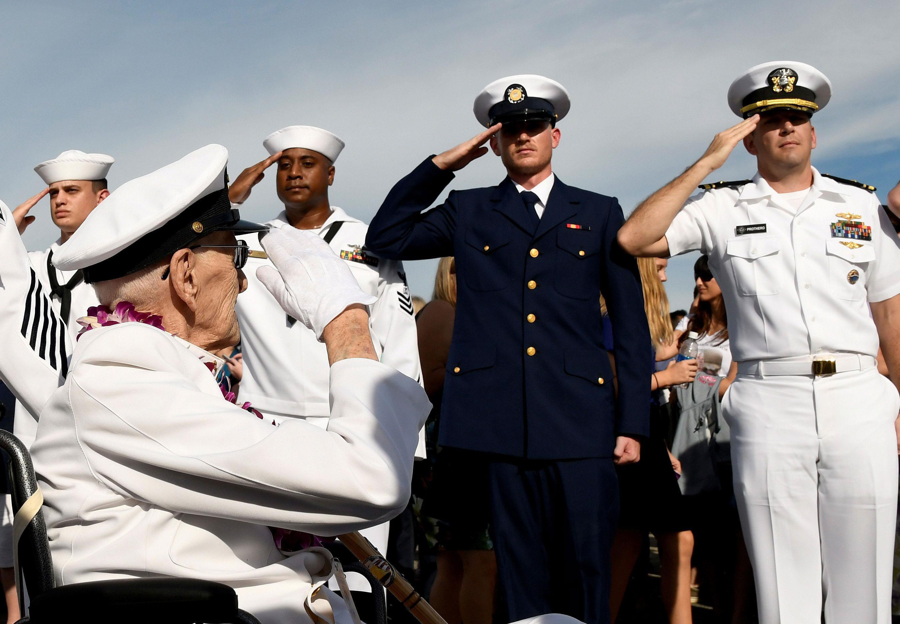 Pearl Harbor survivor Robert Coles salutes active U.S. service members after the ceremonies honoring