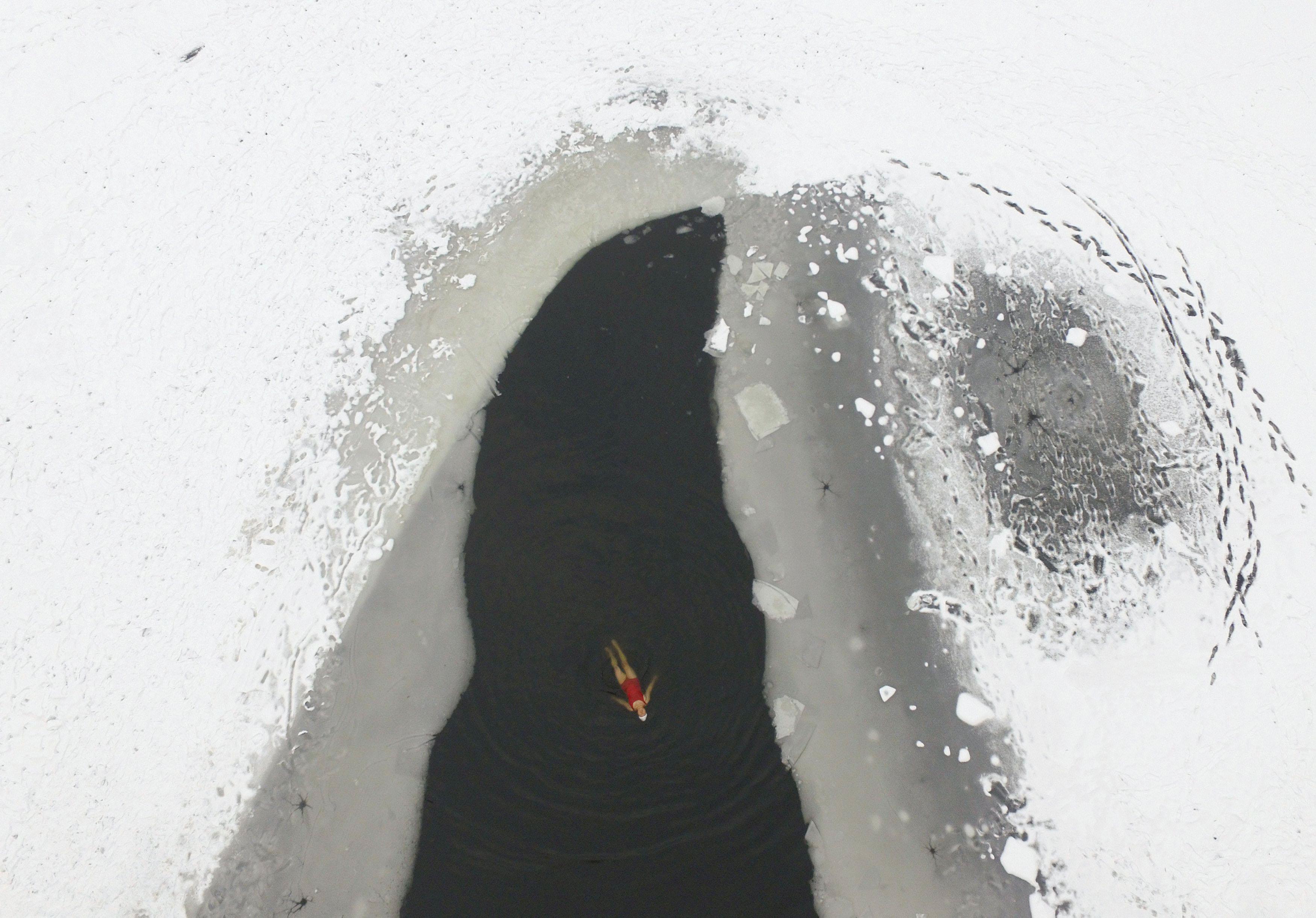 A woman swims in a partially frozen lake at a park in Shenyang