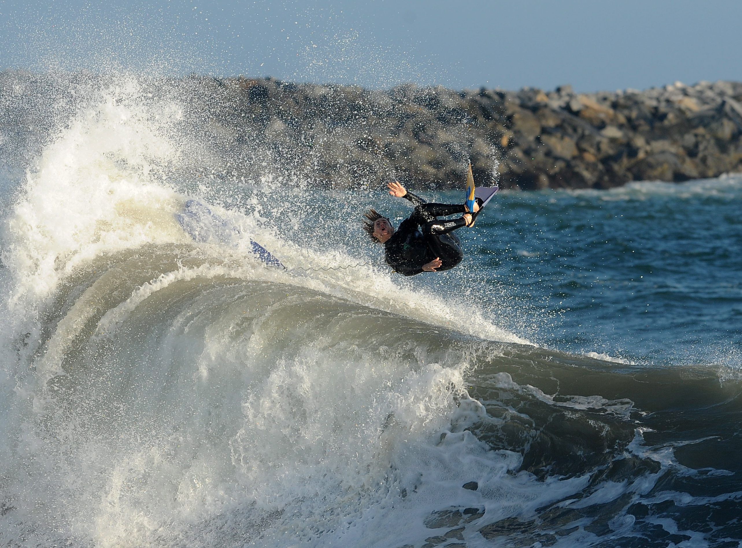 Boogie boarder wykonuje przewrót w przód jadąc na fali w Newport Beach, w Kalifornii