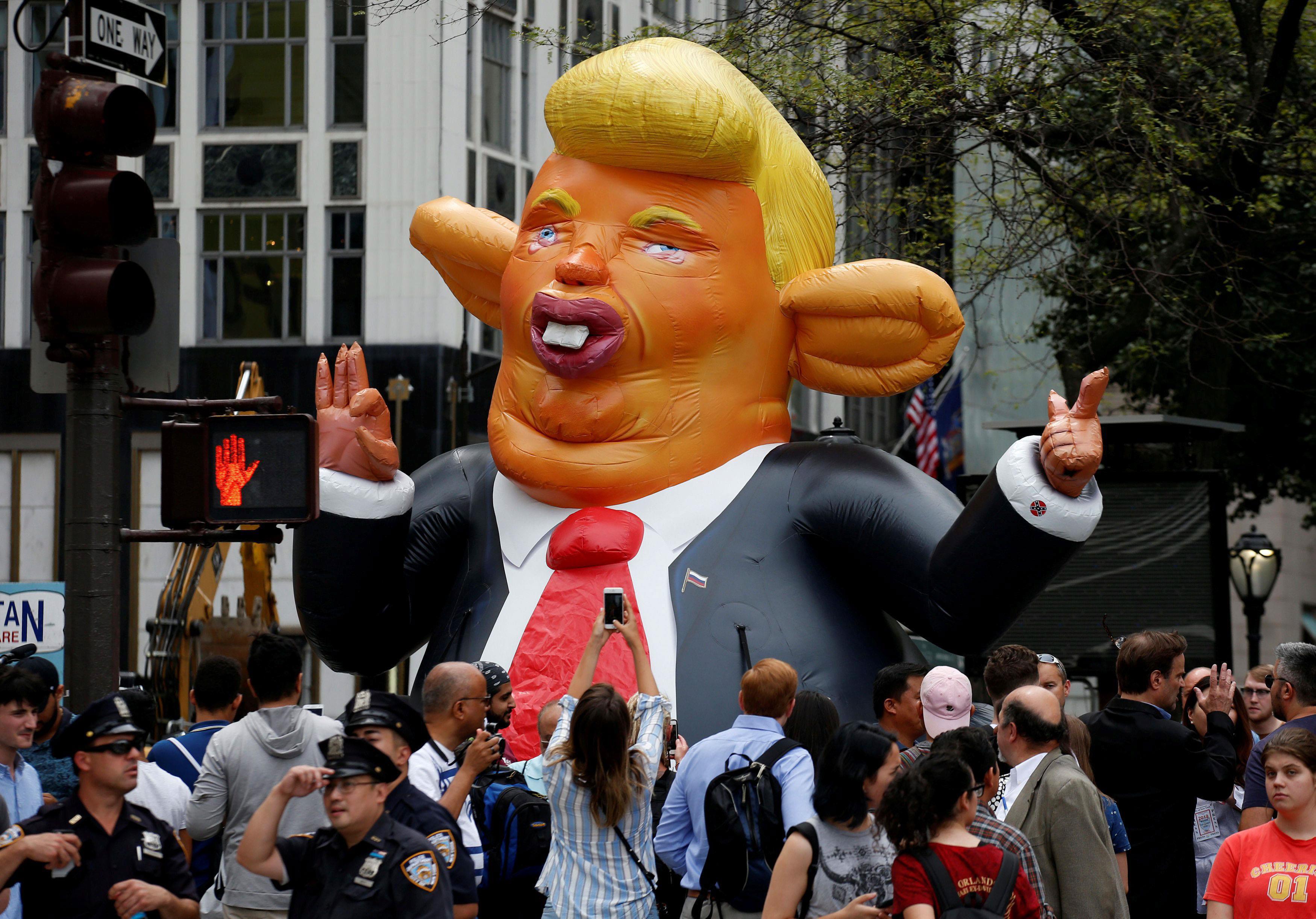 People looks at a giant inflatable rat in the likeness of U.S. President Donald Trump, displayed nea