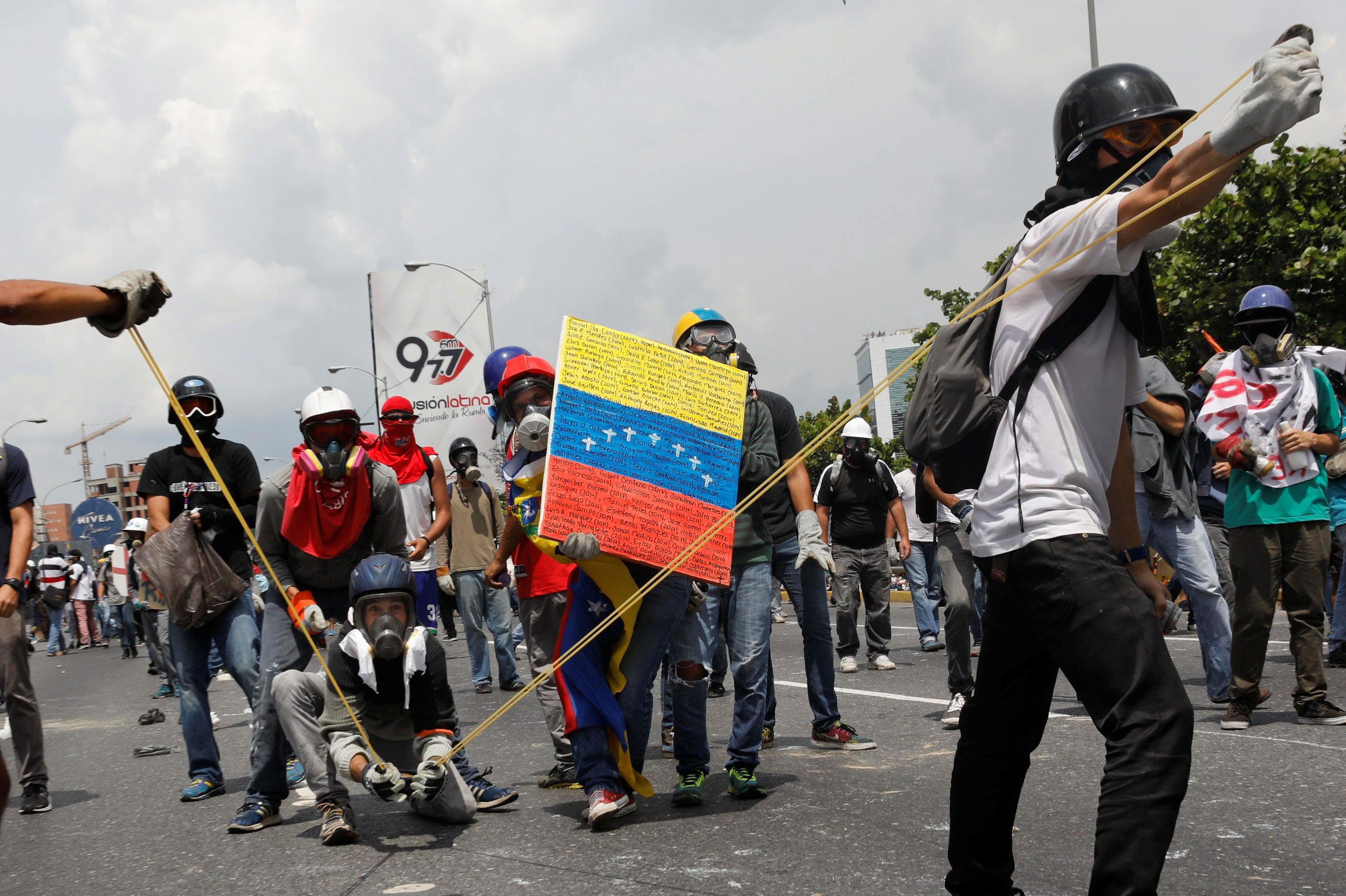 Opposition supporters uses a giant sling shot to throw a 