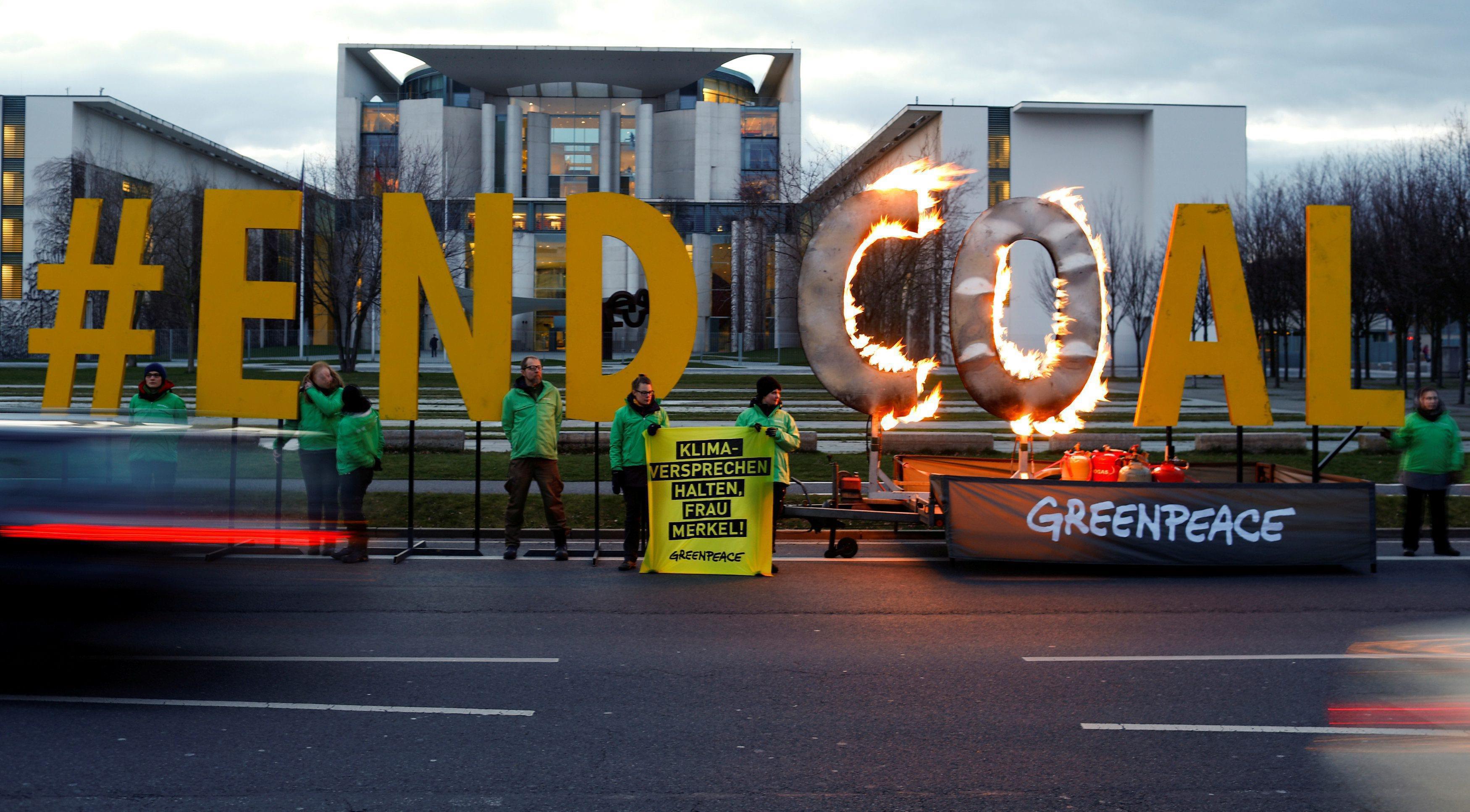 Greenpeace activists set a protest slogan reading 