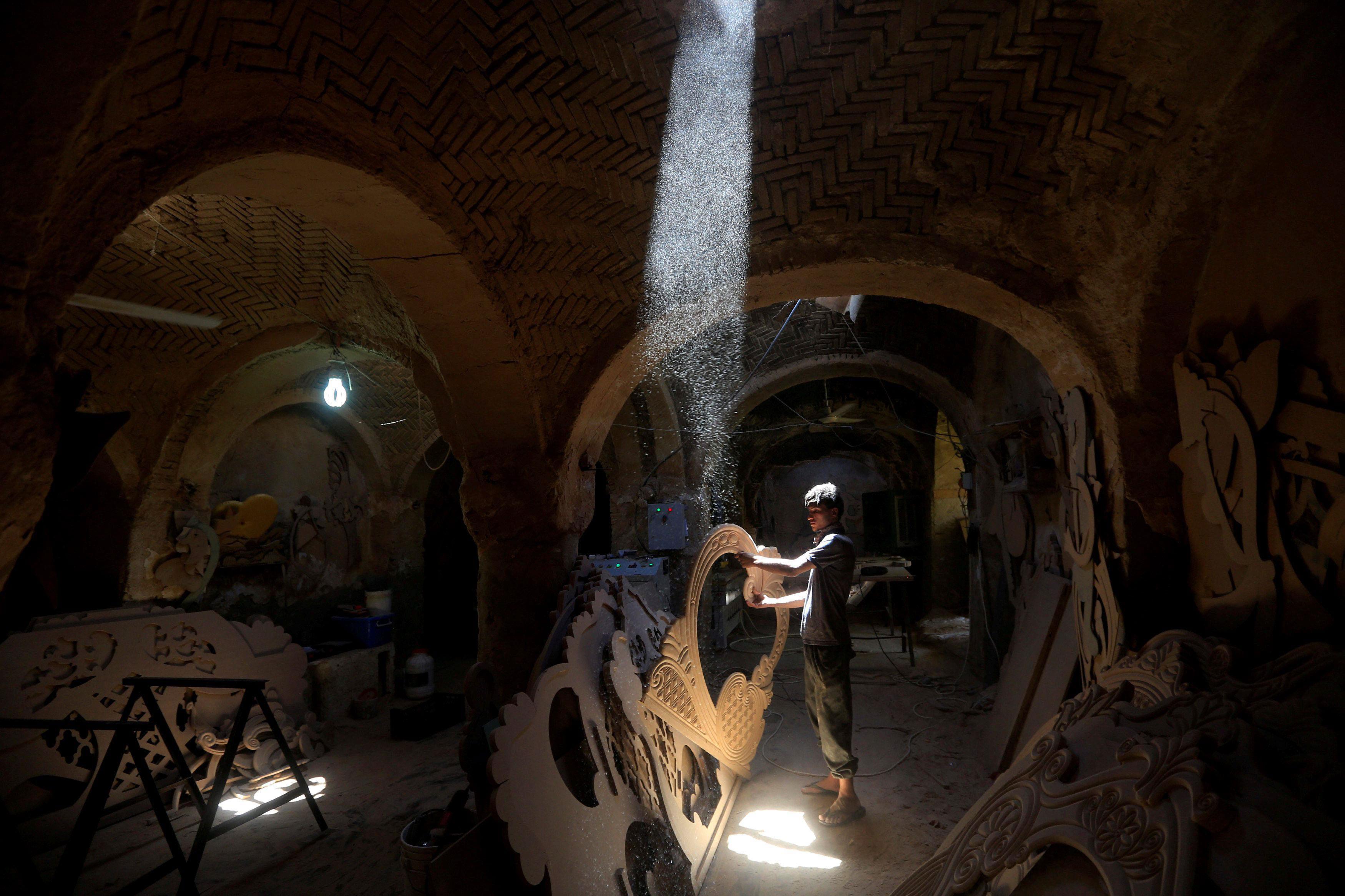 An Iraqi man builds a traditional boat in Najaf