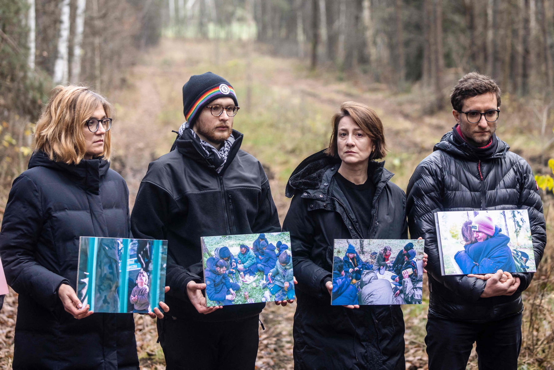 Na granicy. Posłanka Magdalena Biejat, tłumacz Jakub Sypiański, aktorka Maja Ostaszewska i aktywista Iwo Los z Grupy Granica trzymają zdjęcia uchodźców podczas wspólnej konferencji prasowej Grupy Granica, Fundacji Ocalenie i władz lokalnych. Przejście graniczne Kuźnica, 12 listopada 2021 r