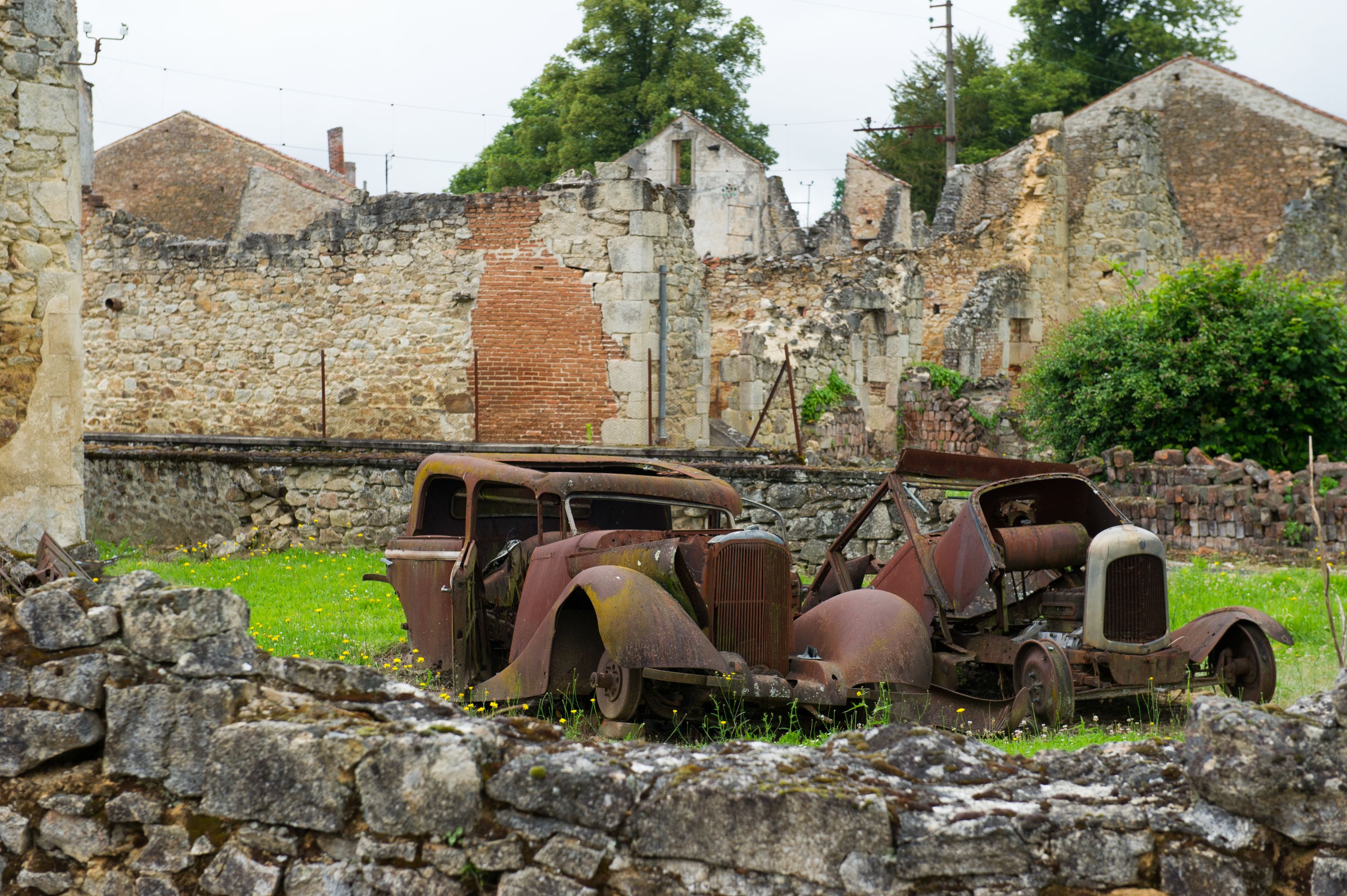 Tragedia rozegrała się <B>10 czerwca 1944 roku</B>. Oddziały SS w odwecie za zabicie przez francuski ruch oporu oficera SS weszły do miasteczka, wyganiając mieszkańców z domów i <B>rozstrzeliwując wszystkich bez wyjątku - mężczyzn, kobiety i dzieci</B>. <BR><BR> Tych, którzy nie zginęli od razu, Niemcy zapędzili do kościoła. Budynek <b>podpalili, wrzucali do środka granaty, strzelali do osób, które próbowały uciec</b>. Tego dnia wymordowali <b>642 mieszkańców miasteczka</b>. Przeżyła 47-letnia kobieta, której udało się wyskoczyć przez okienko w kościele i uciec, pięciu mężczyzn oraz jedno dziecko. <BR><BR> Jak się potem okazało, Niemcy wymierzyli tę okrutną karę mieszkańcom nie tego miasta, które planowali spacyfikować. W rzeczywistości oficer SS został zabity w <b>Oradour-sur-Vayres</b>. <BR><BR> Miasteczka nigdy nie odbudowano. Jego <b>ruiny zamieniono po wojnie w ogromne muzeum</b>. Wizyta w tym miejscu robi duże wrażenie. Na ulicach i podwórkach wciąż stoją <b>auta zabitych mieszkańców</B>, gdzieniegdzie pod ścianą domu widać oparty zardzewiały rower, można również zobaczyć część osobistych przedmiotów ofiar. <BR><BR> <b>Oradour-sur-Glane</B> to jedna z czterech miejscowości, jakie w czasie wojny spotkał taki los. W podobny sposób, mordując mieszkańców w zemście, Niemcy potraktowali również Lidice w Czechach, Mazinote we Włoszech oraz wieś Sochy na Lubelszczyźnie. Tragedię tej ostatniej opisała <b>Anna Janko w książce