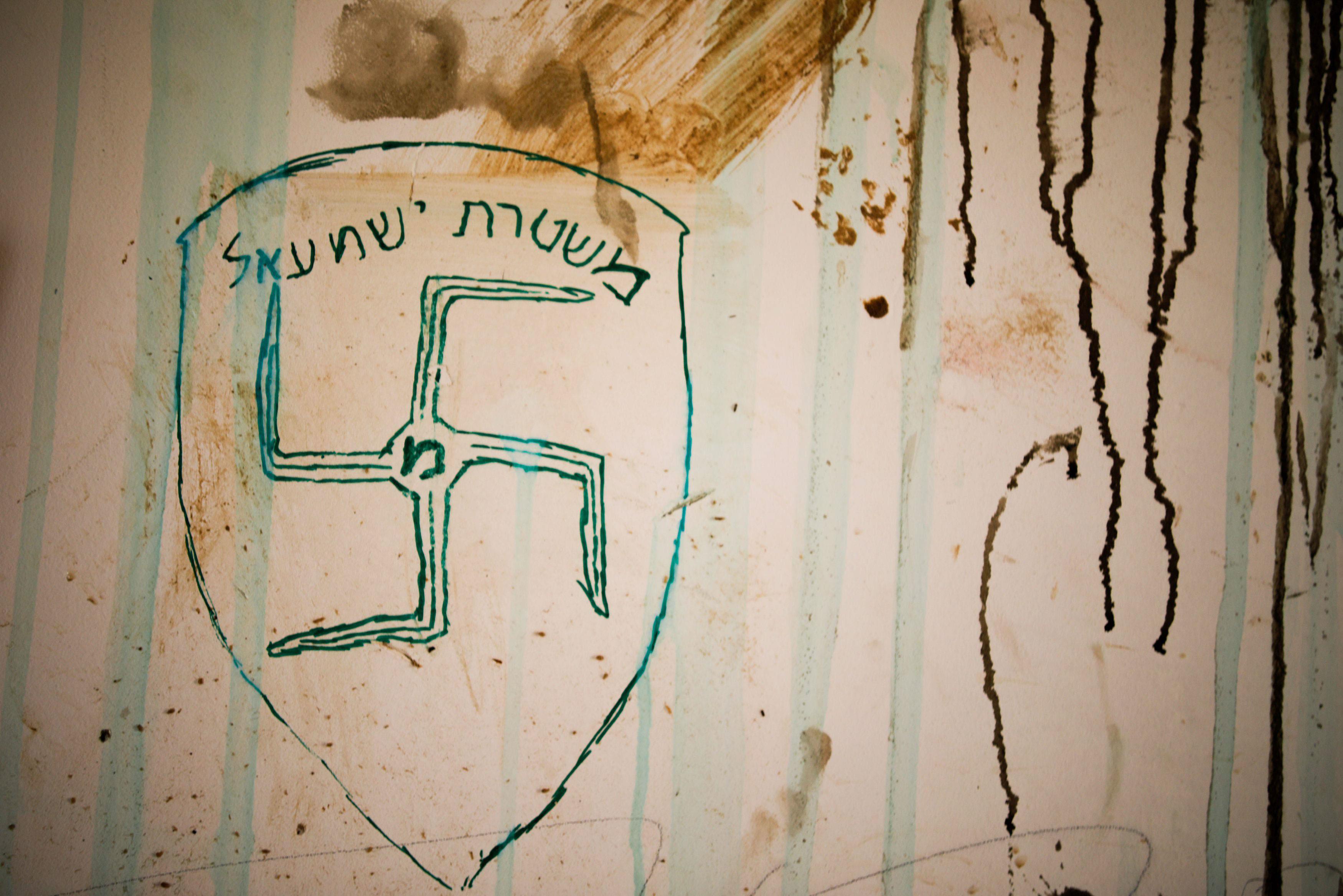 A swastika and text in Hebrew reading 