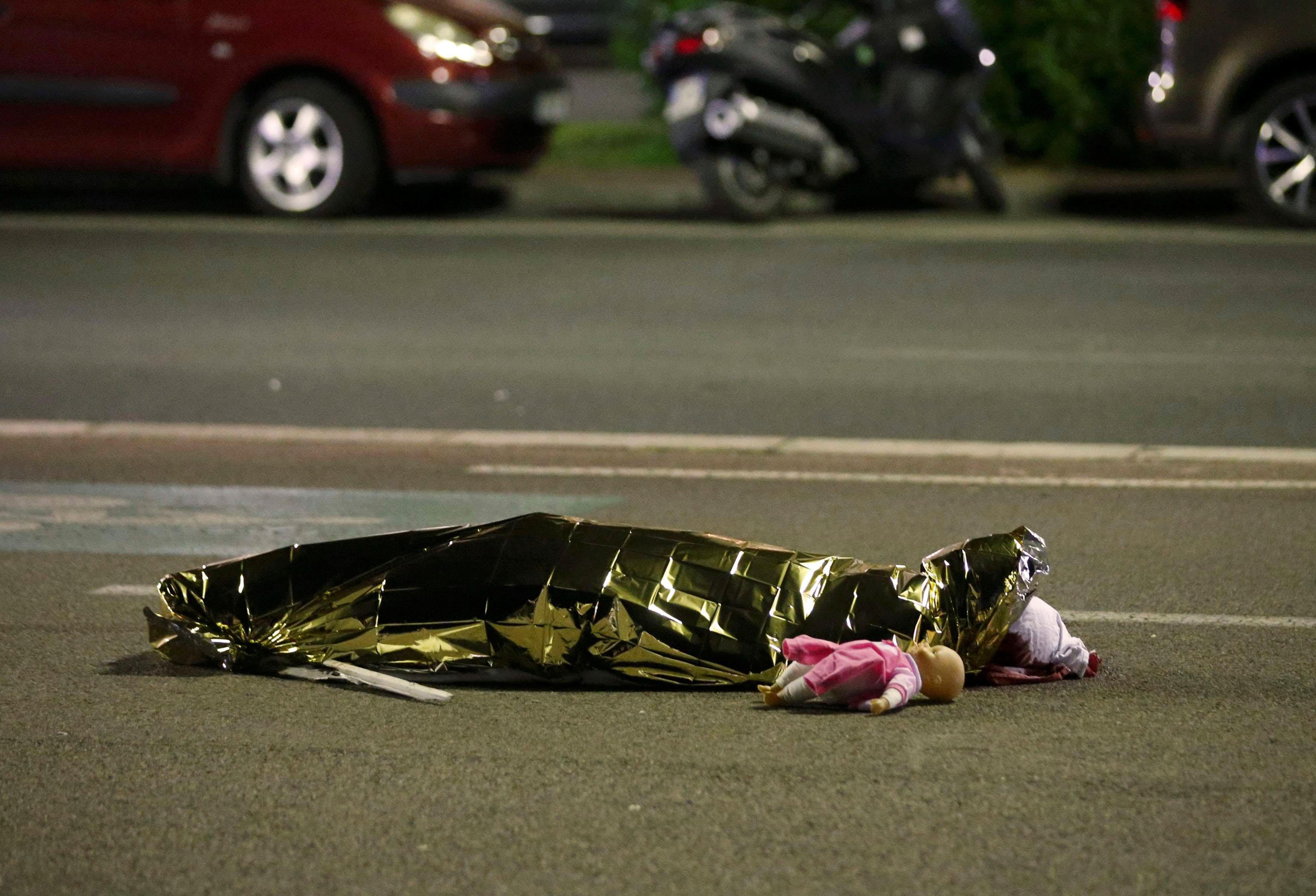 A body is seen on the ground after at least 30 people were killed in the southern French town of Nic