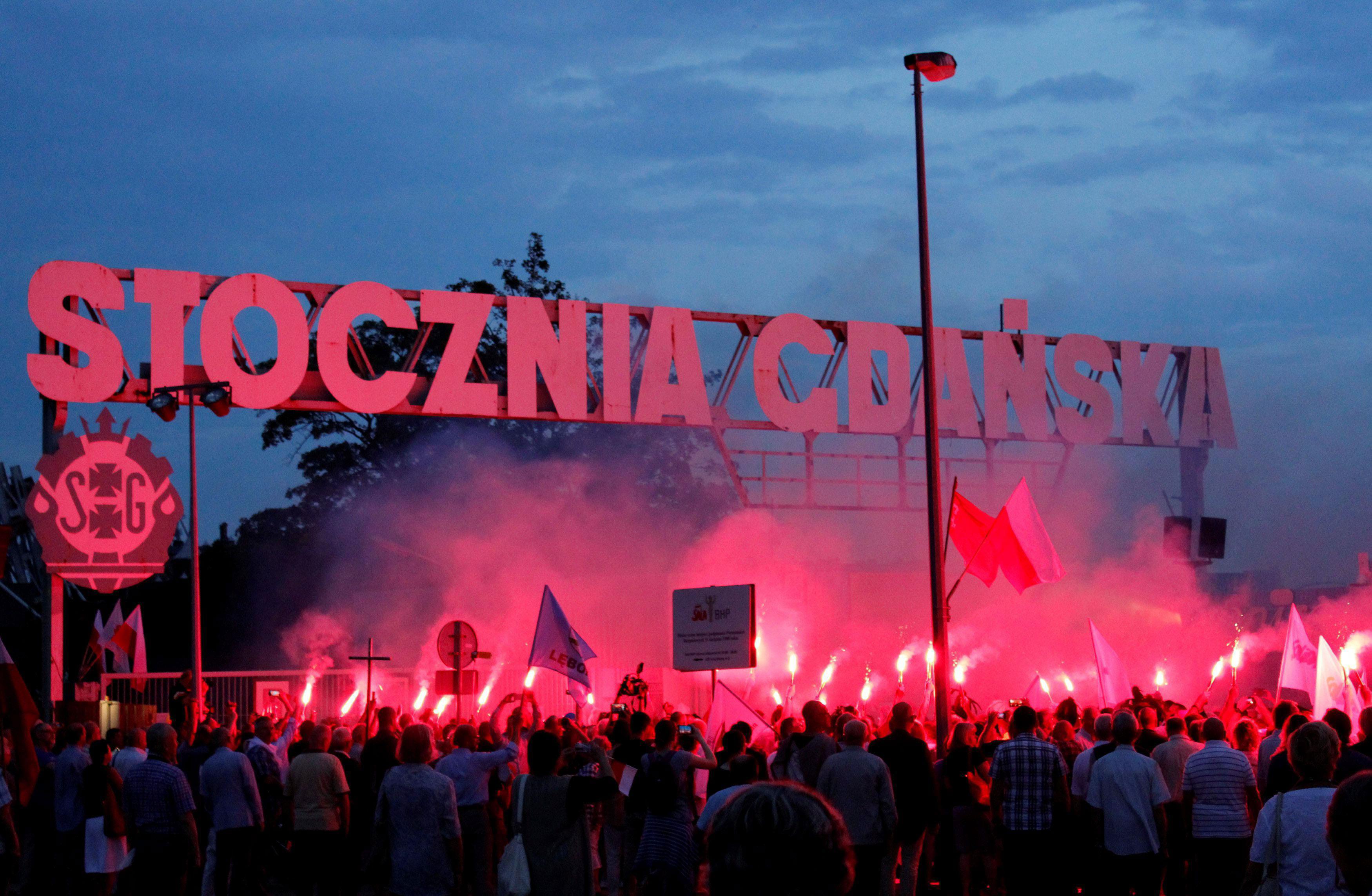 People light flares in front of the shipyard entrance during the 37th anniversary of emerging Solida