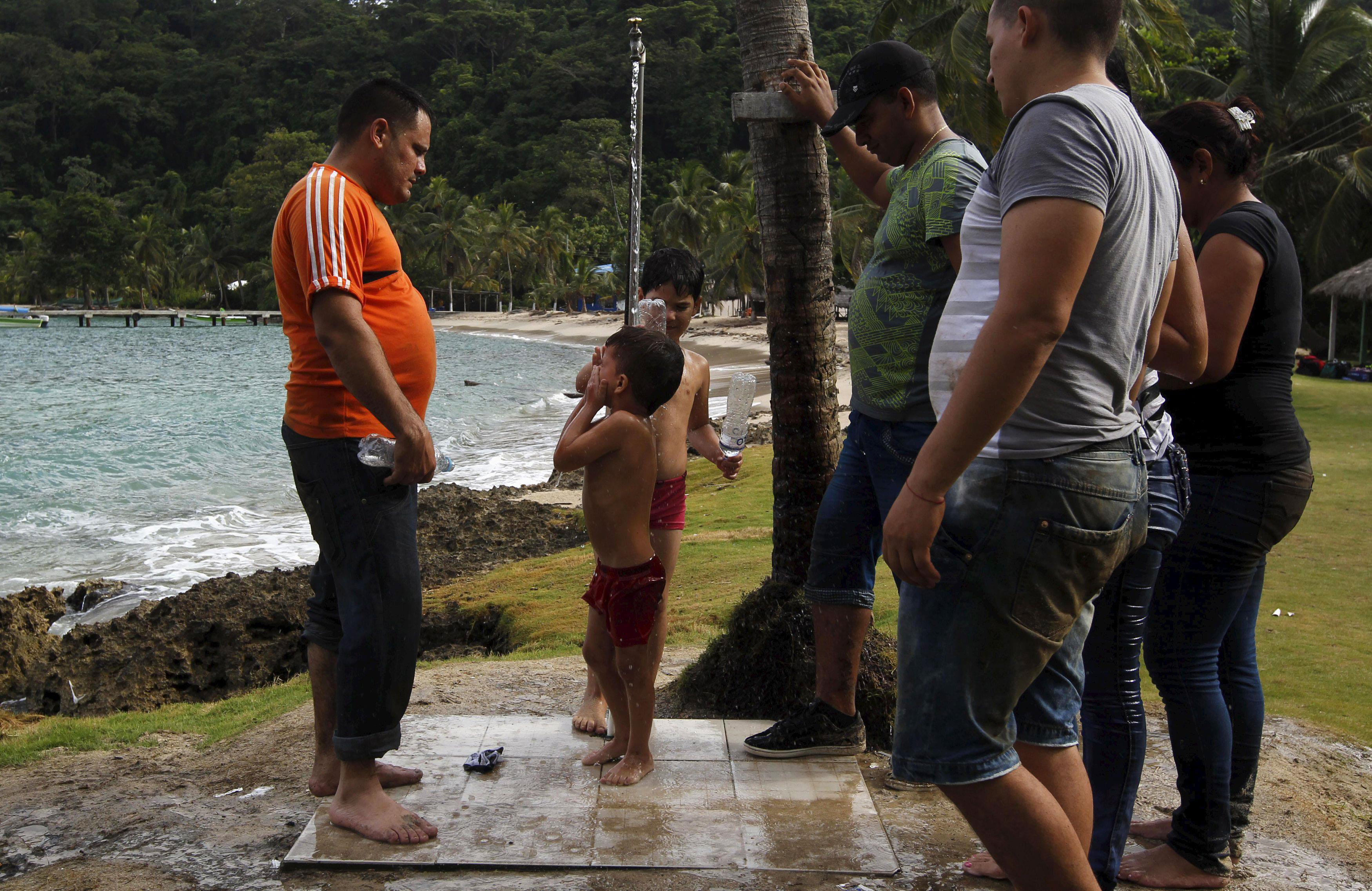 A Cuban migrant child freshen up as others wait for their turn after they crossed the border from Co