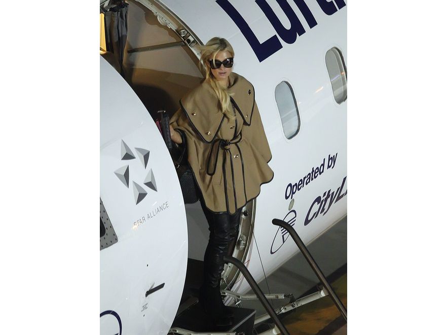 Paris Hilton na lotnisku w Polsce. Elegancja z pazurem: elegancki płaszcz w połączeniu ze skórzanymi spodniami.