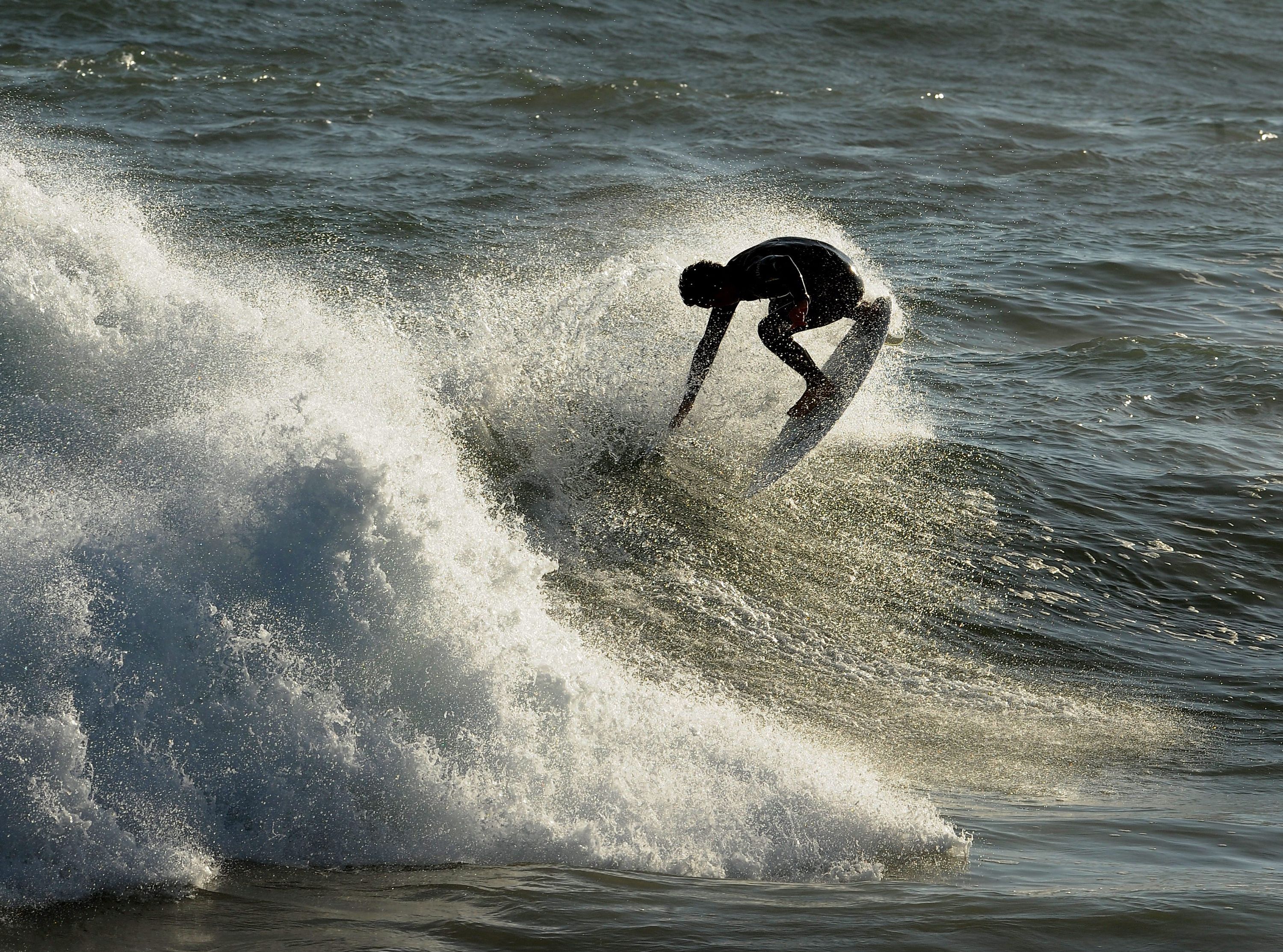 Surfer wykonuje obrót wokół własnej osi na fali w Newport Beach, w Kalifornii