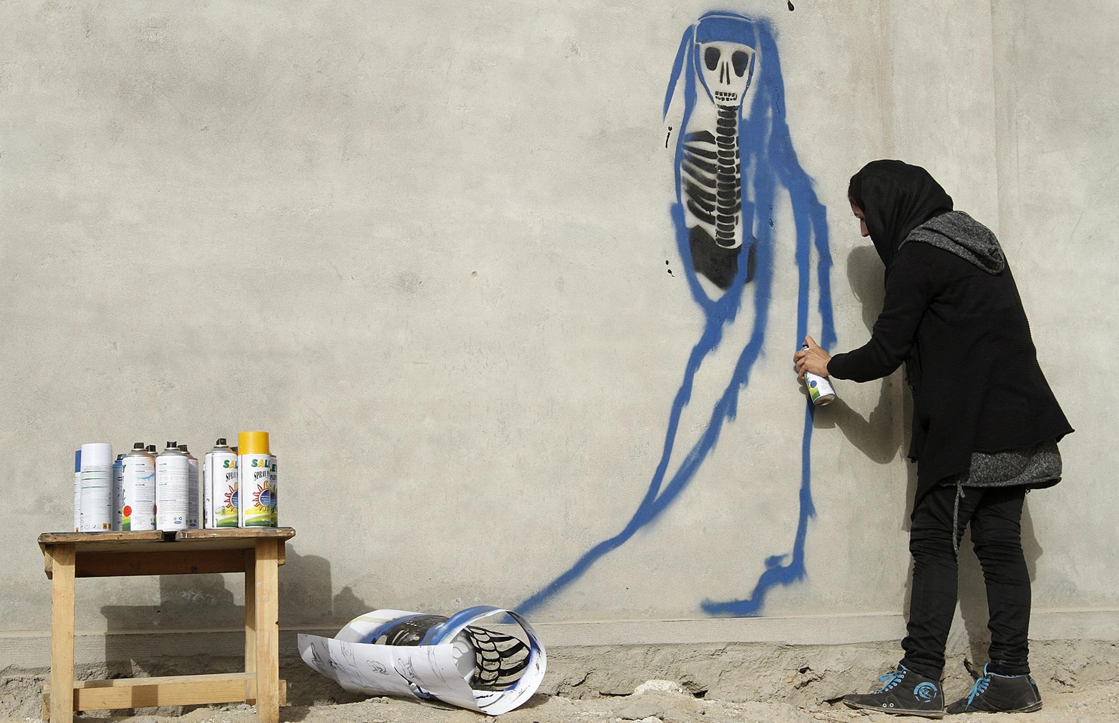 Malina Suliman maluje graffiti na murach Kandaharu
