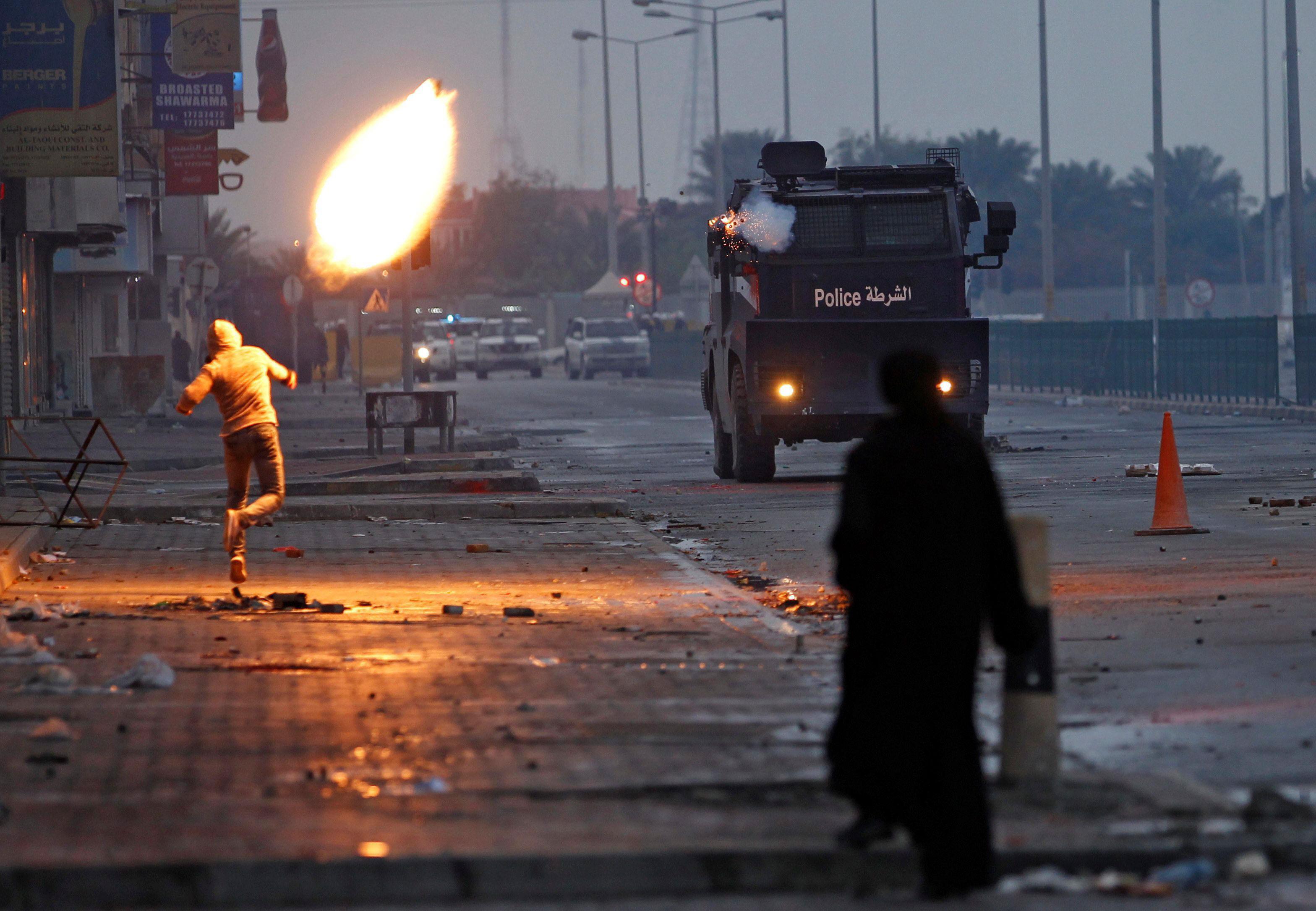 A protester throws molotove at riot police armoured personnel carrier and at the same time tear gas 