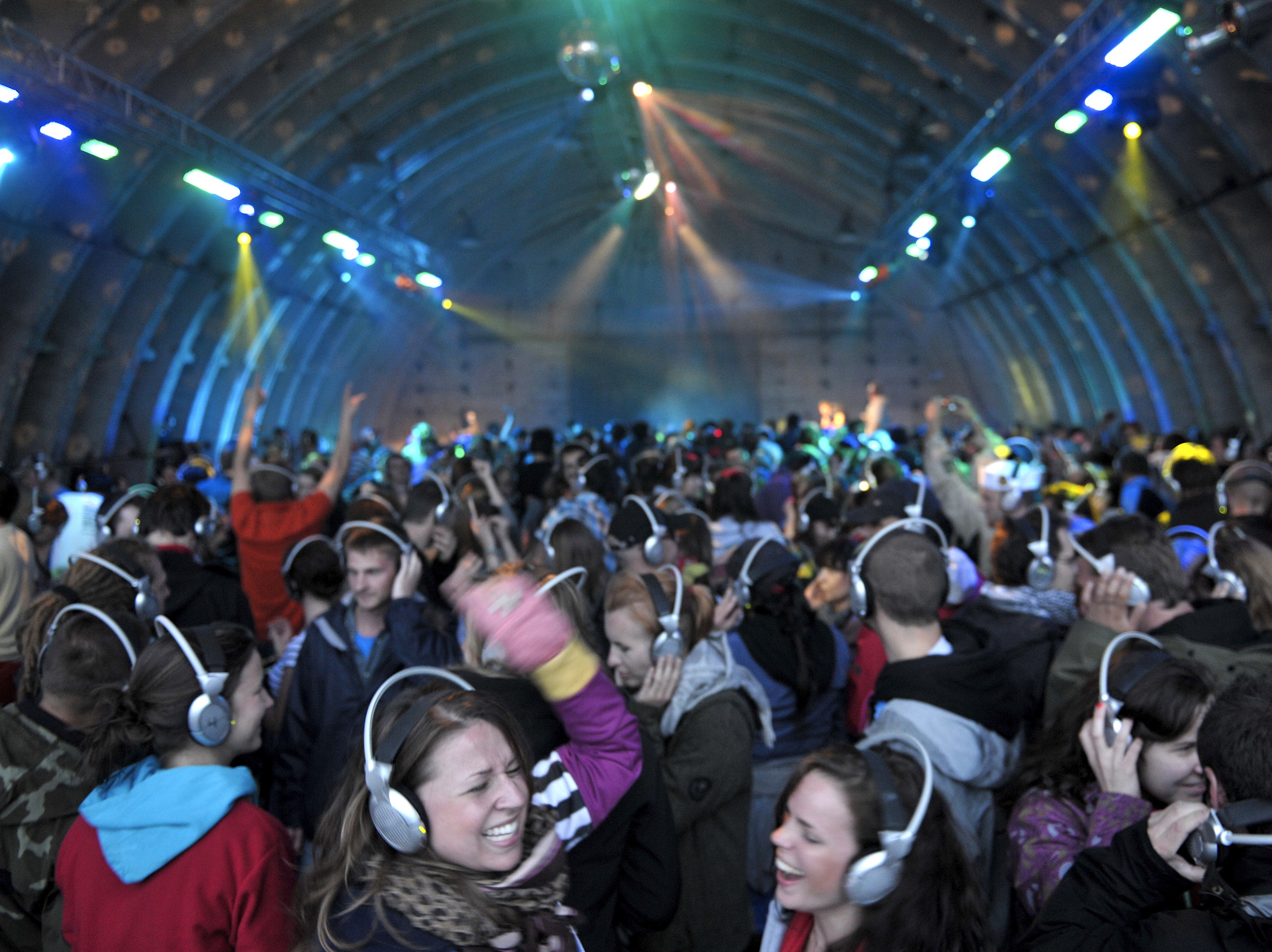 Zabawa w hangarze Silent Disco przy muzyce, którą słychać tylko przez słuchawki