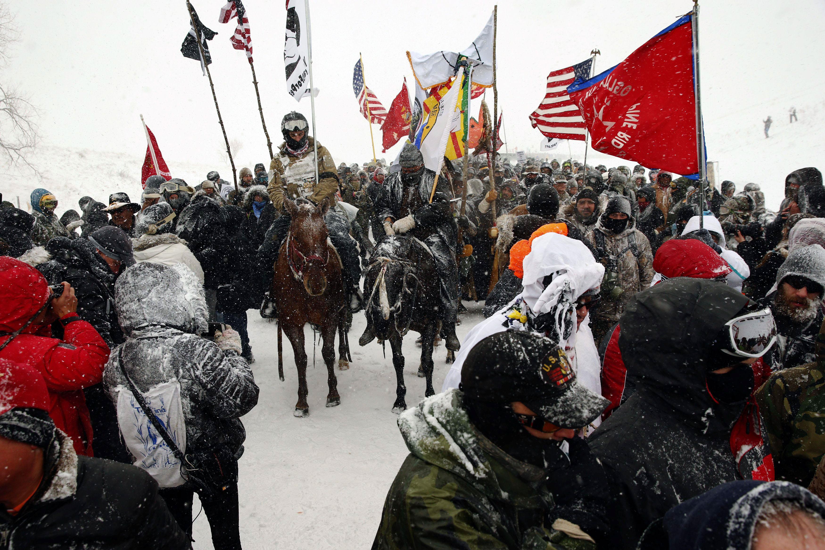 Veterans march with activists near Backwater Bridge just outside the Oceti Sakowin camp during a sno