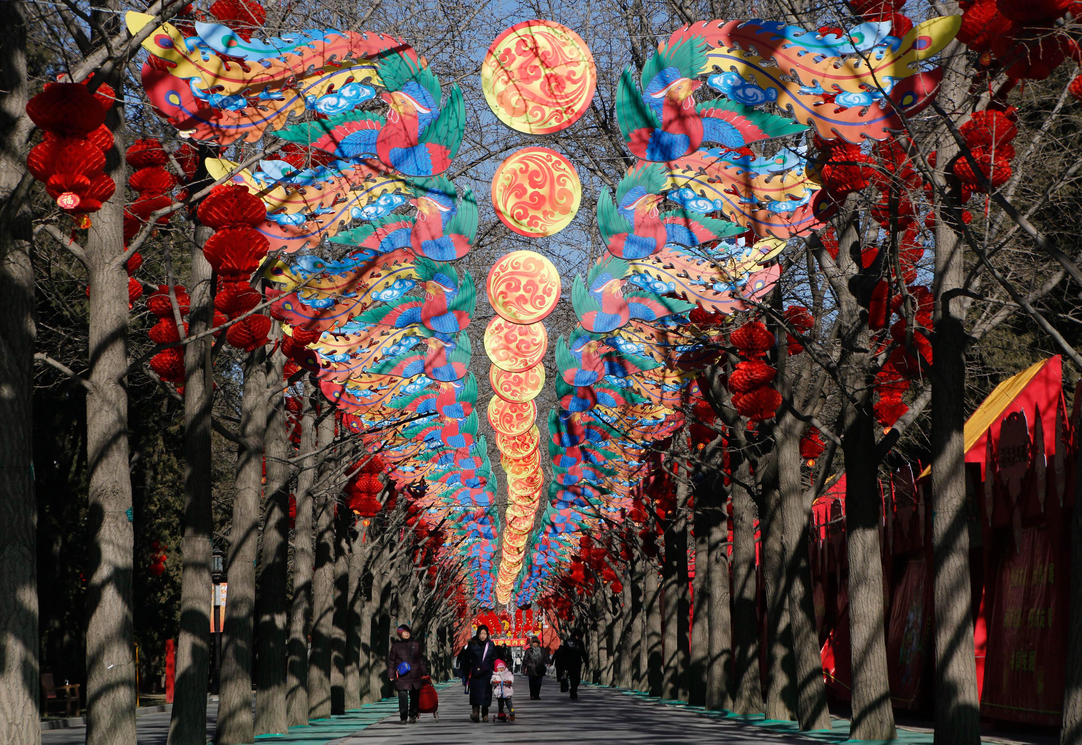 Visitors walk beneath decorations set up for the upcoming Spring Festival celebrations in Ditan Park