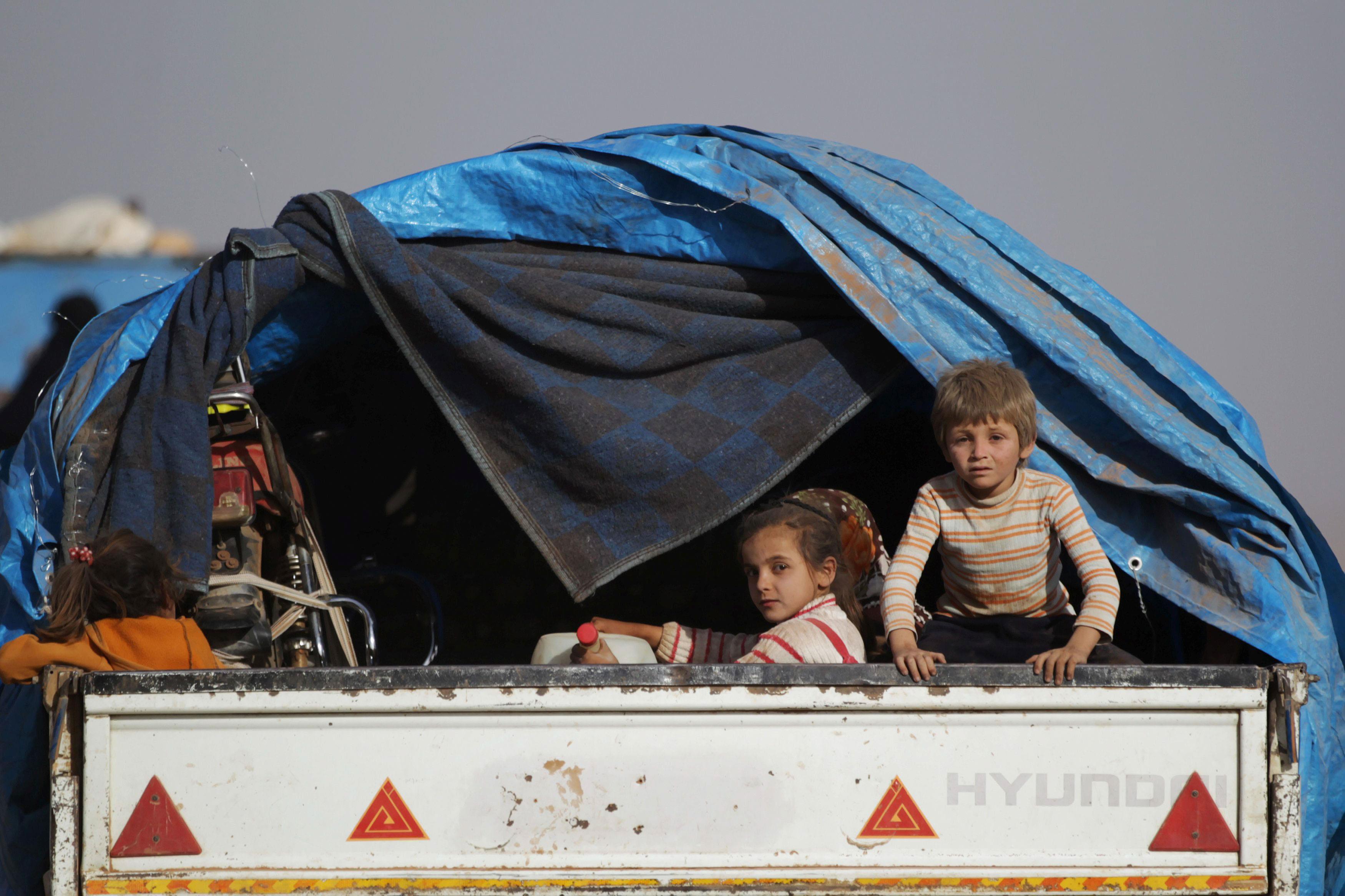 Children who fled from Islamic State-controlled areas ride a pick-up truck to the northern Syrian re