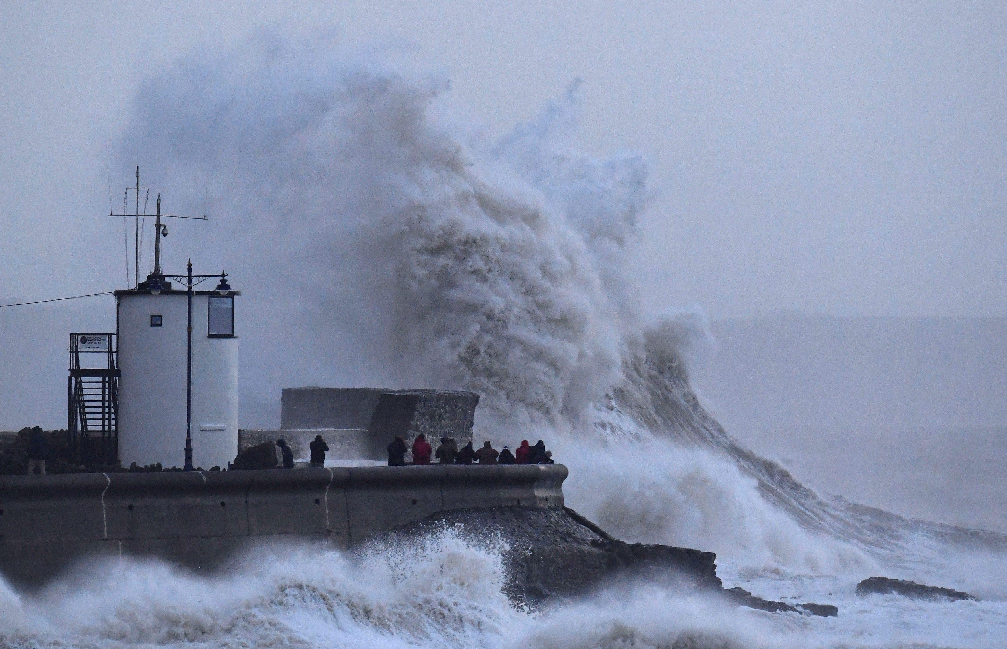 People view large waves and high winds associated with Storm Eleanor as they hit the lighthouse and 