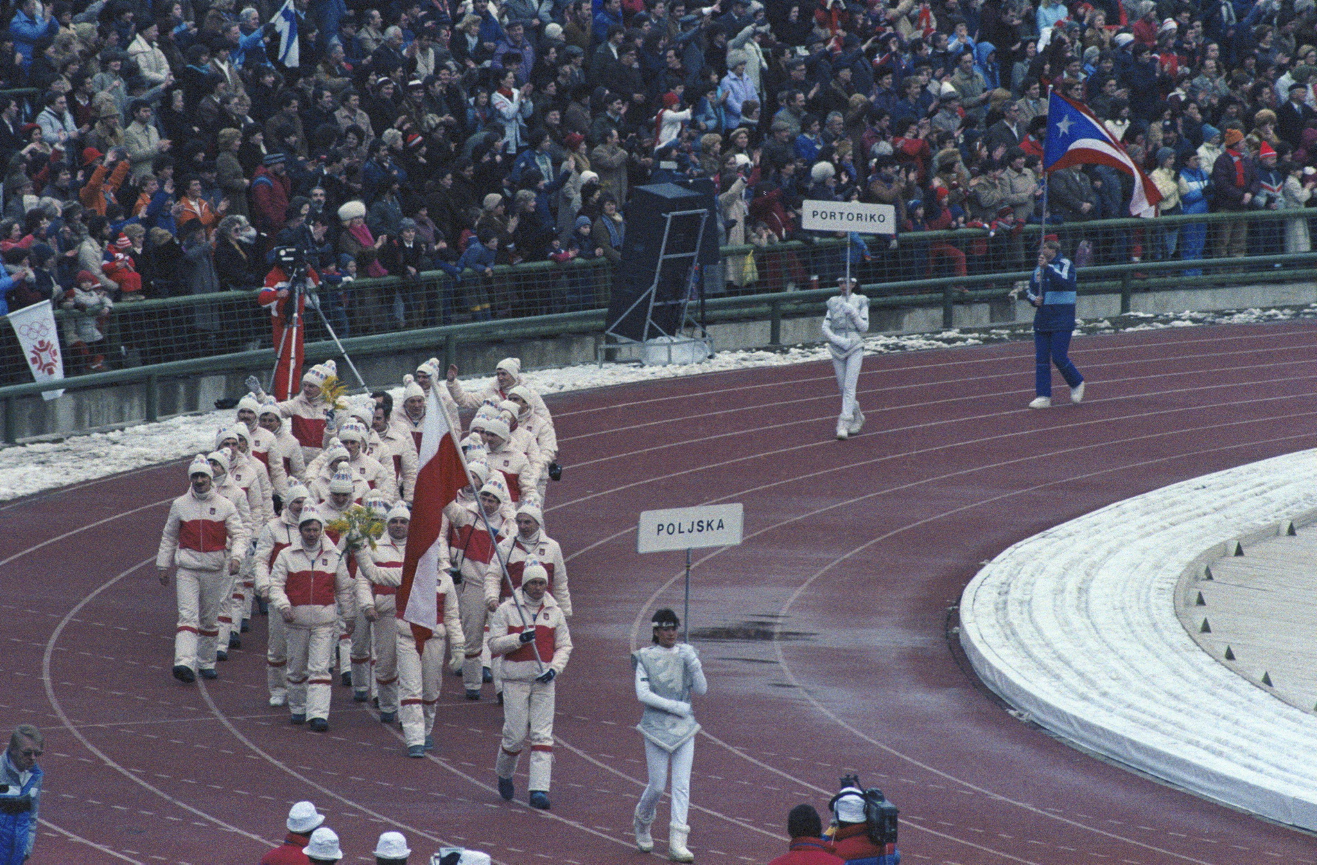 Polska reprezentacja podczas ceremonii zakończenia zimowych igrzysk olimpijskich w Sarajewie. Polską flagę niesie biegacz narciarski Józef Łuszczek, luty 1984 r.