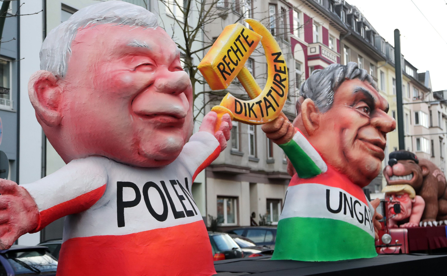 Politycy trzymają wspólnie sierp i młot z napisem