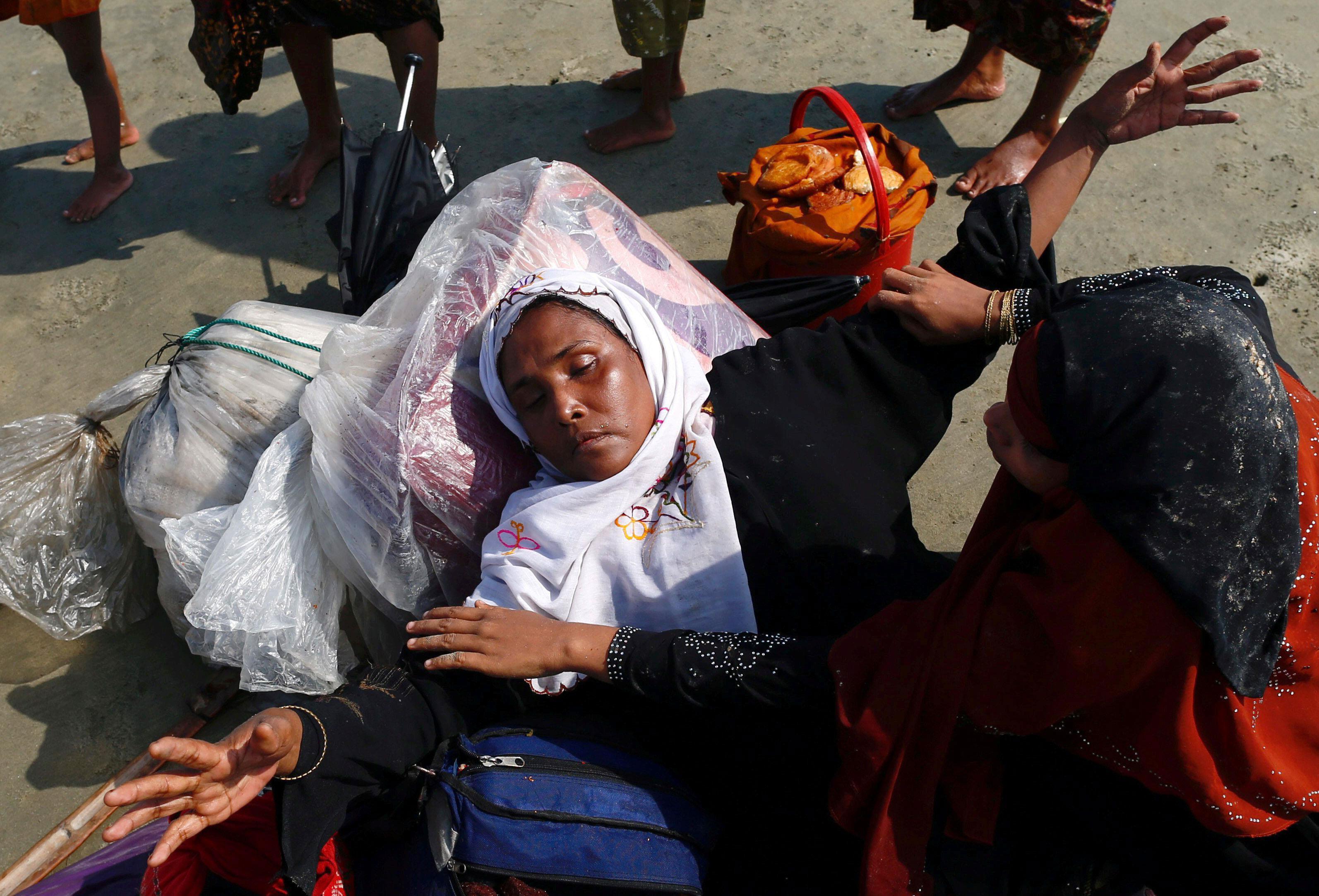 A Rohingya refugee woman reacts after crossing the Bangladesh-Myanmar border by boat through the Bay