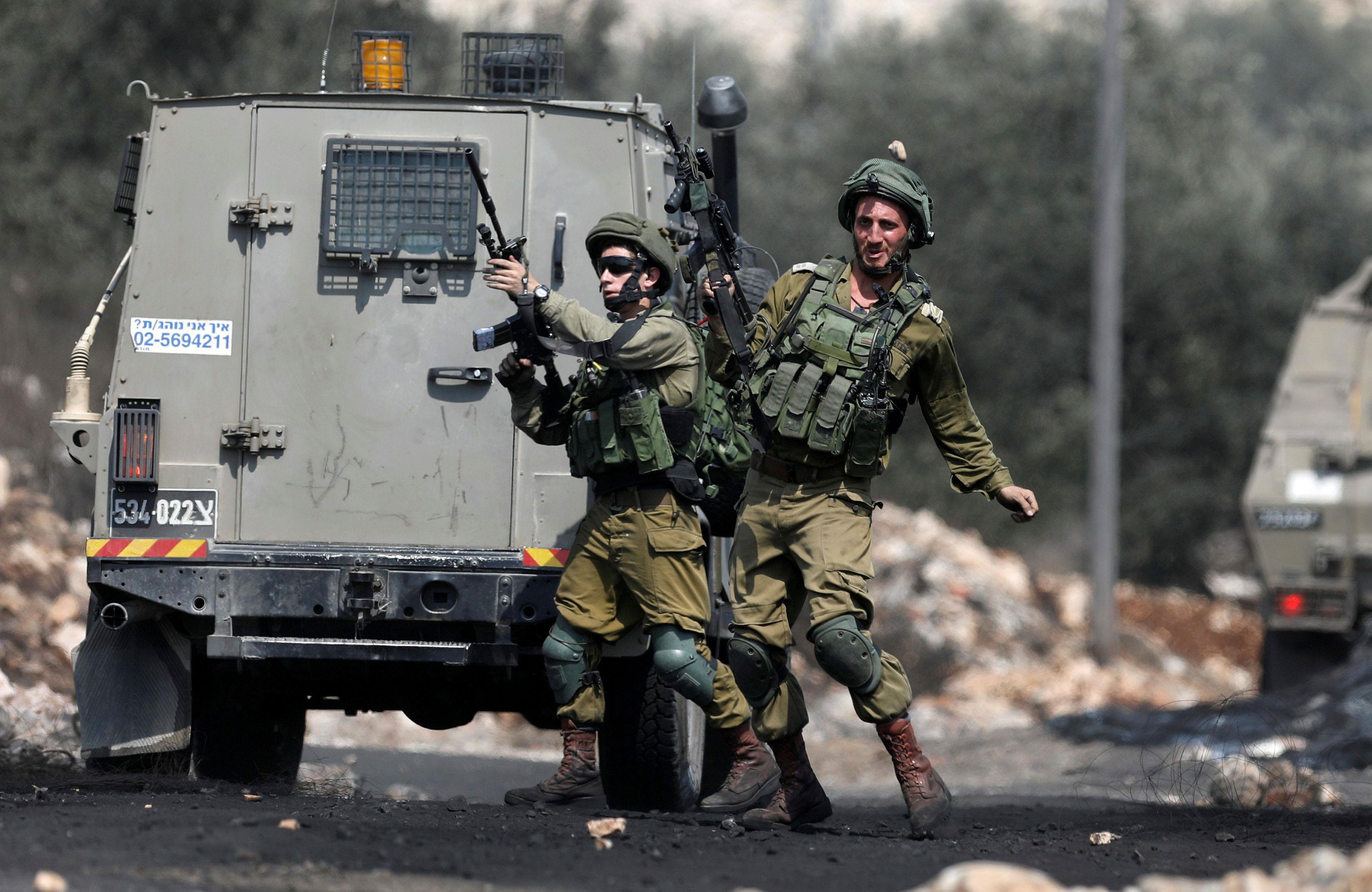 A stone is thrown at an Israeli soldier during clashes with Palestinians following a protest against