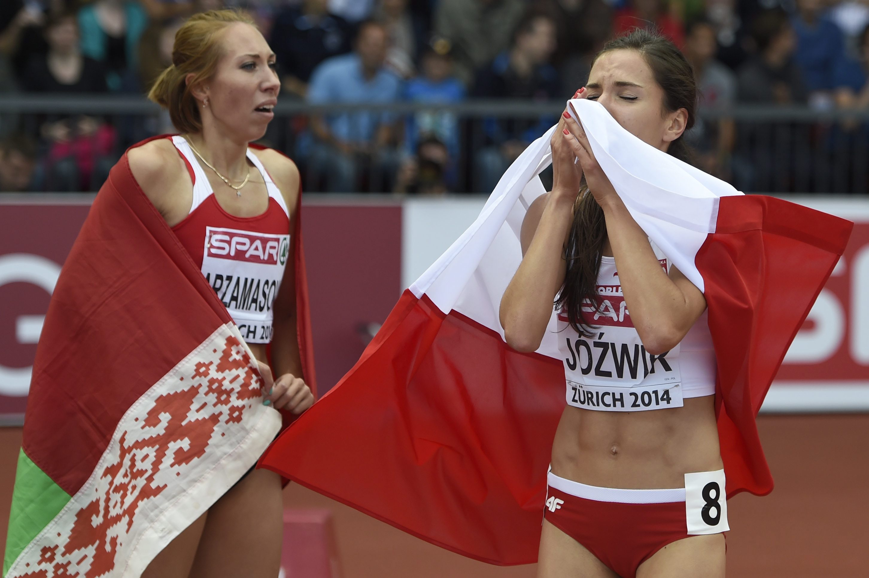 Owinięta w biało-czerwoną flagę Polka Joanna Jóźwik cieszy się po zdobyciu brązowego medalu w finałowym biegu kobiet na dystansie 800 metrów