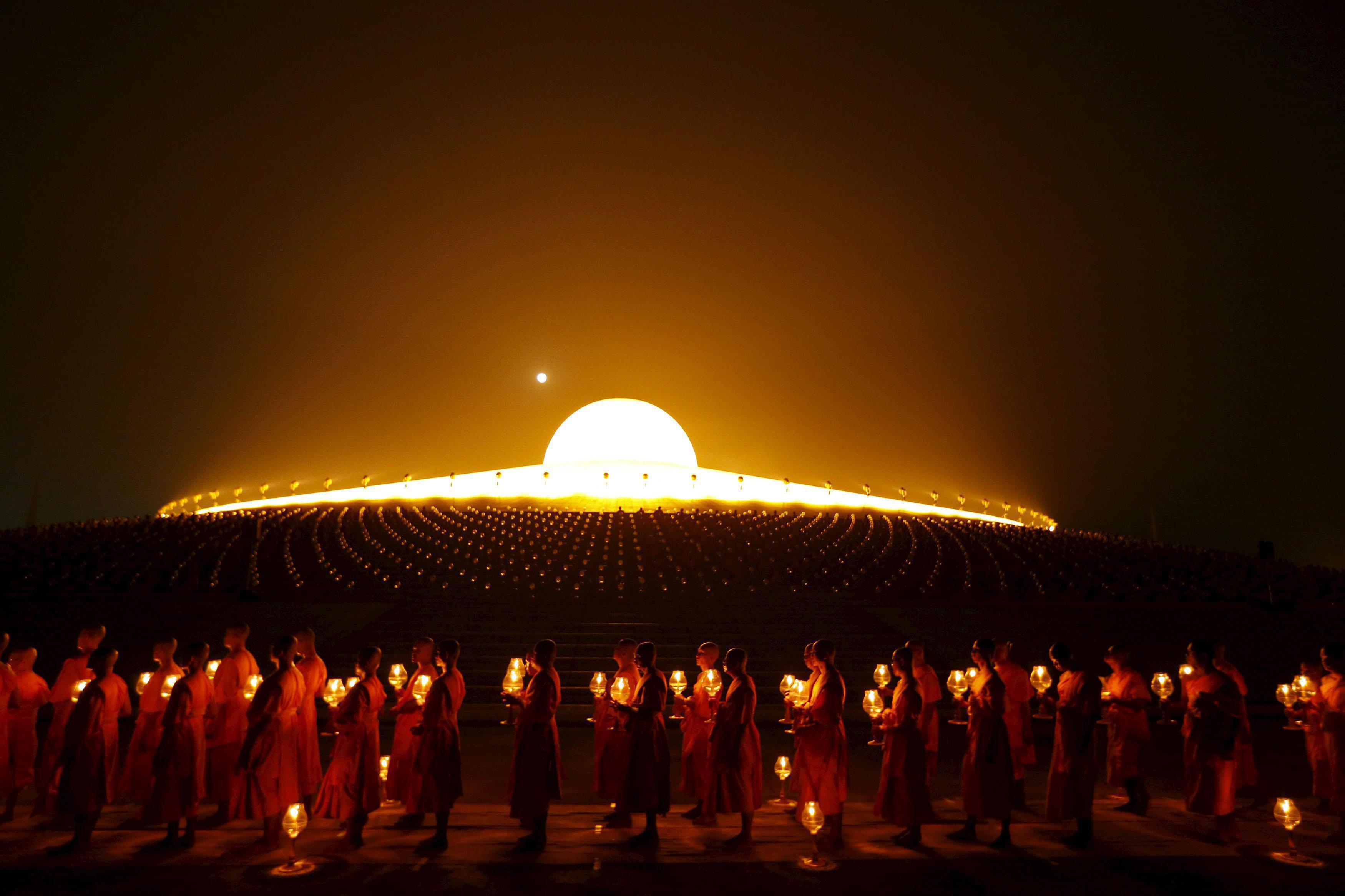 Buddhist monks pray at Wat Phra Dhammakaya temple during a ceremony on Makha Bucha Day in Pathum Tha
