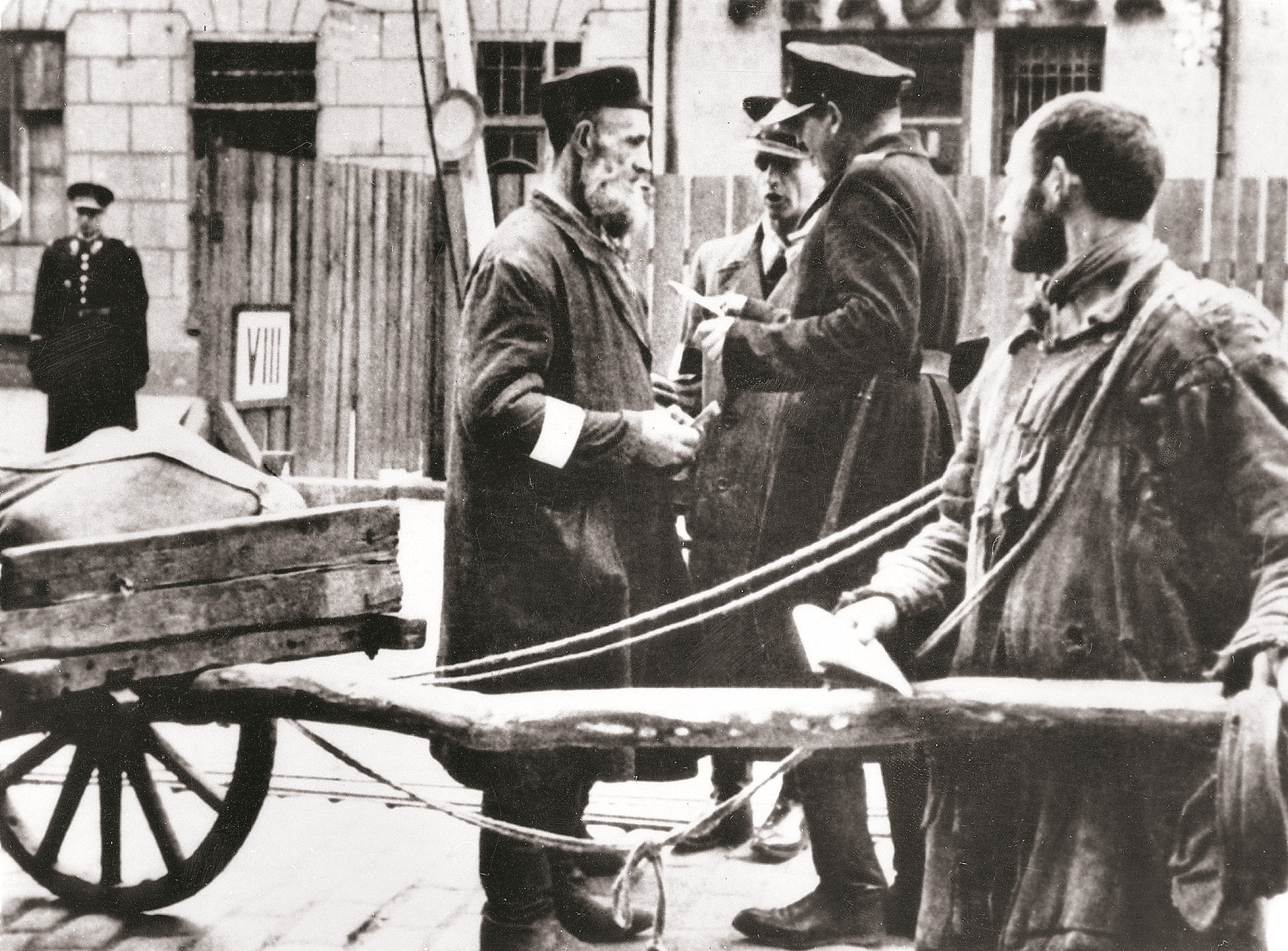 Policjanci polski i żydowski sprawdzają dokumenty przy wejściu do getta, Warszawa, lata 40. XX w.