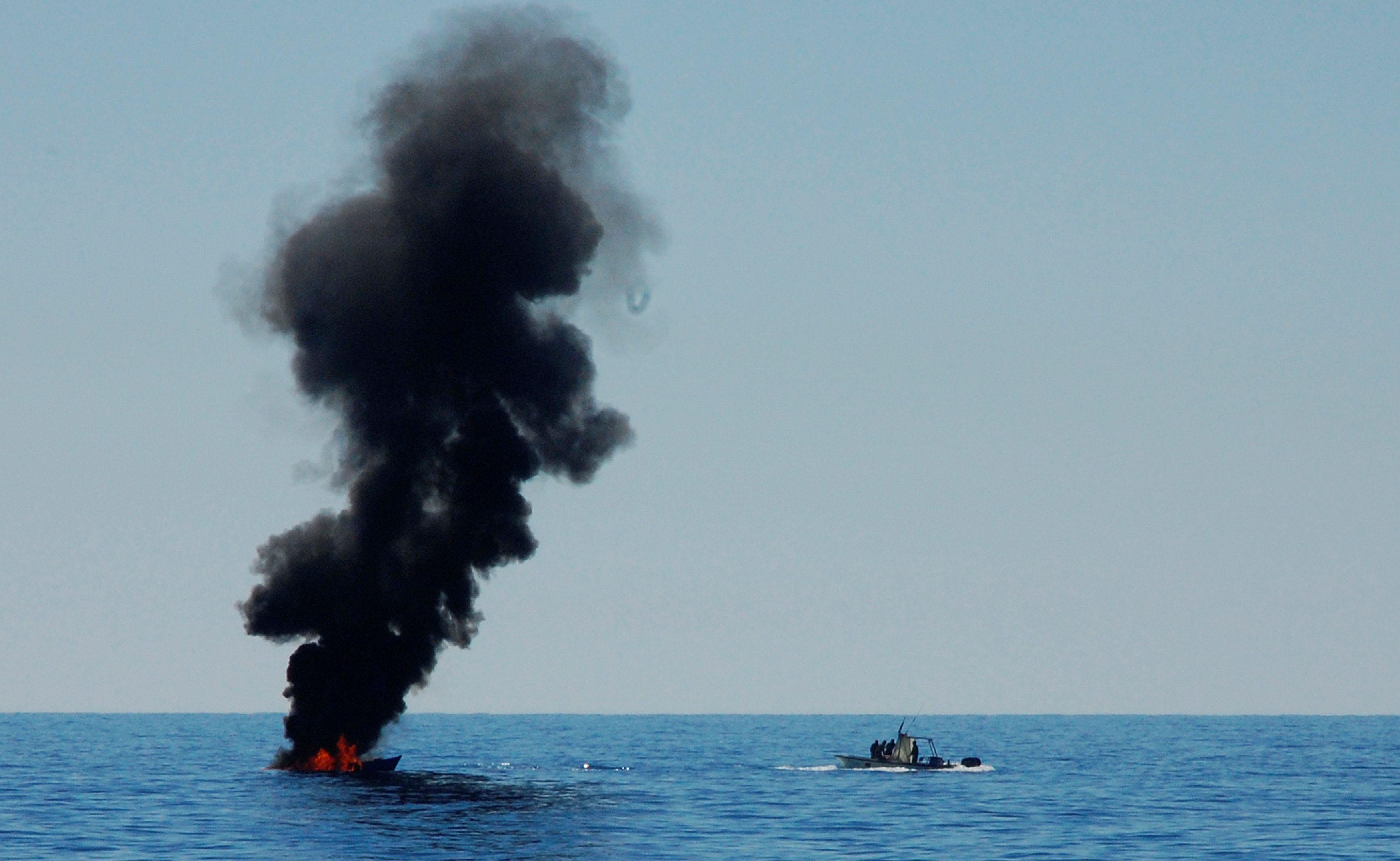 A migrant boat is set on fire by the Libyan coastguard after NGO ships rescued the migrants about 20