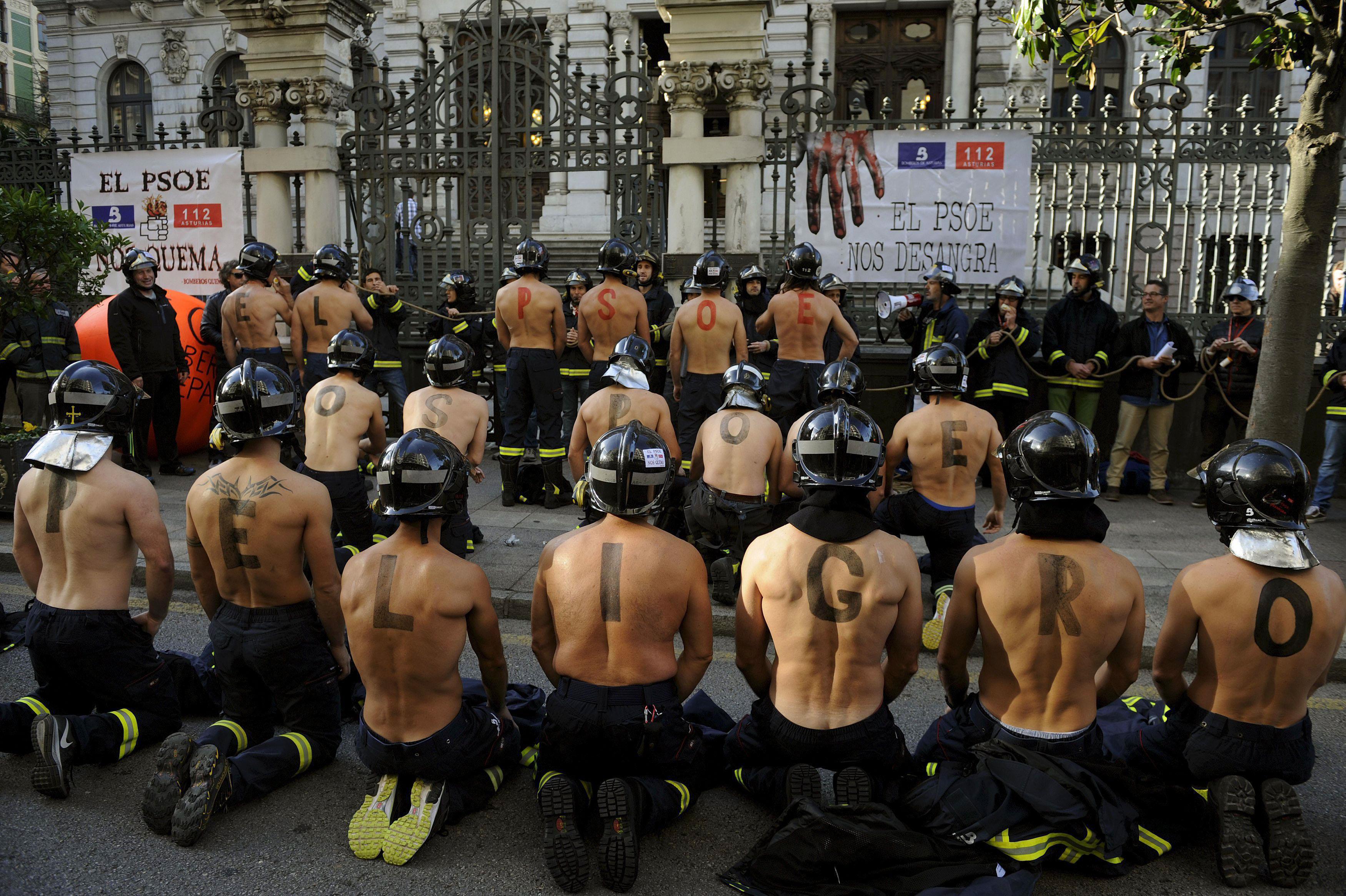 Firefighters take part in a protest in front of the regional parliament of Asturias demanding better