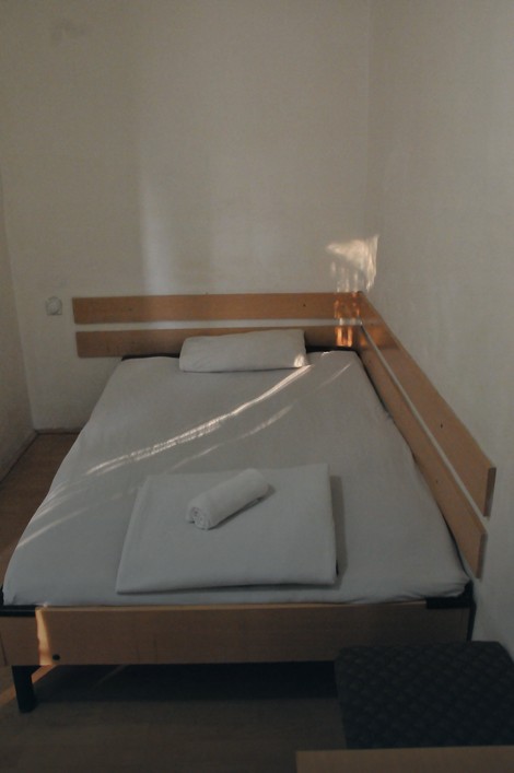 U sobi od desetak kvadrata su jednostavan bračni krevet, stočić sa dva taburea, ogledalo...