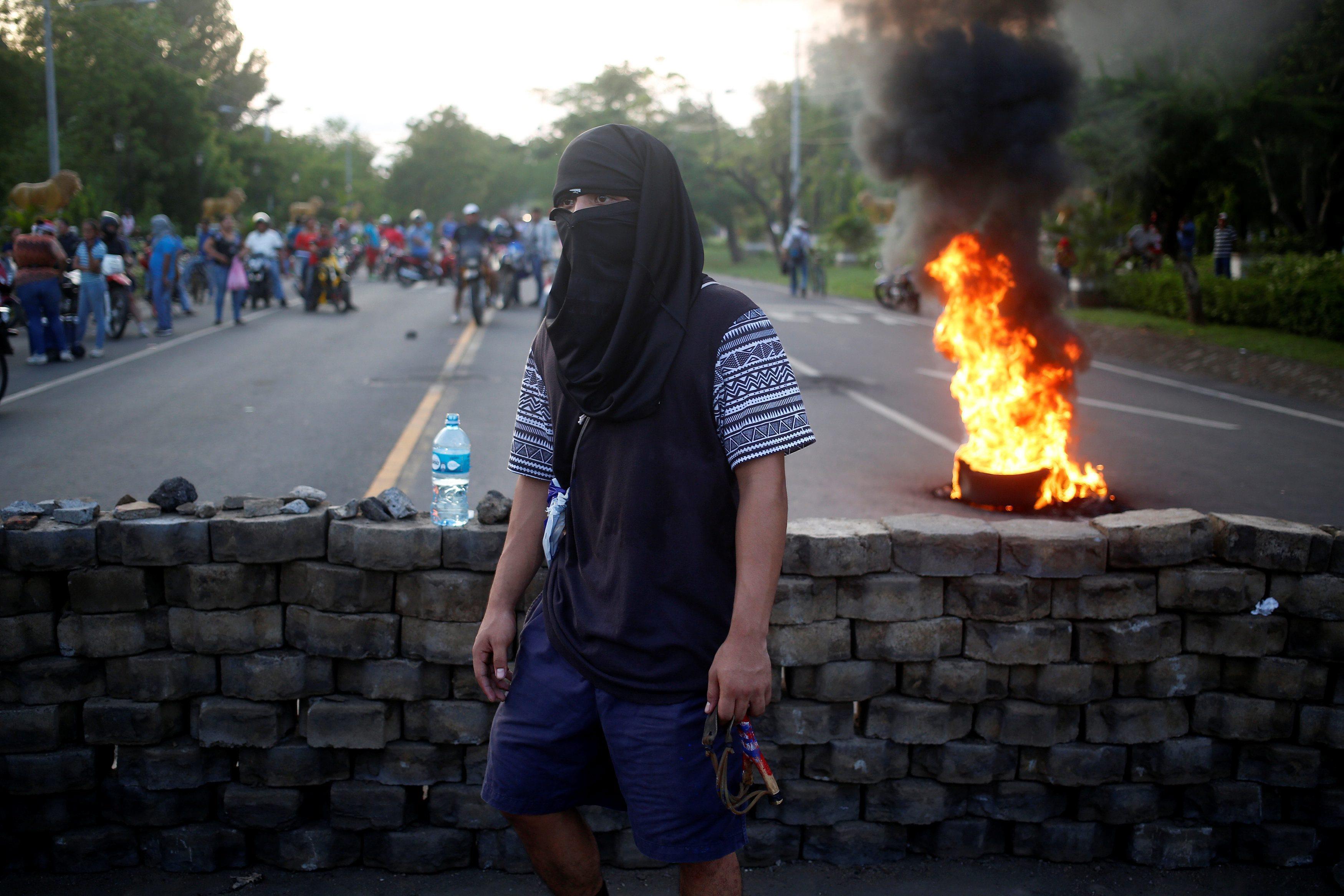 A masked protester takes part in a protest against President Daniel Ortega's government in Leon