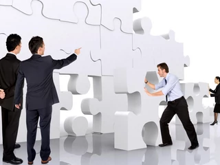 business teamwork - business men making a puzzle