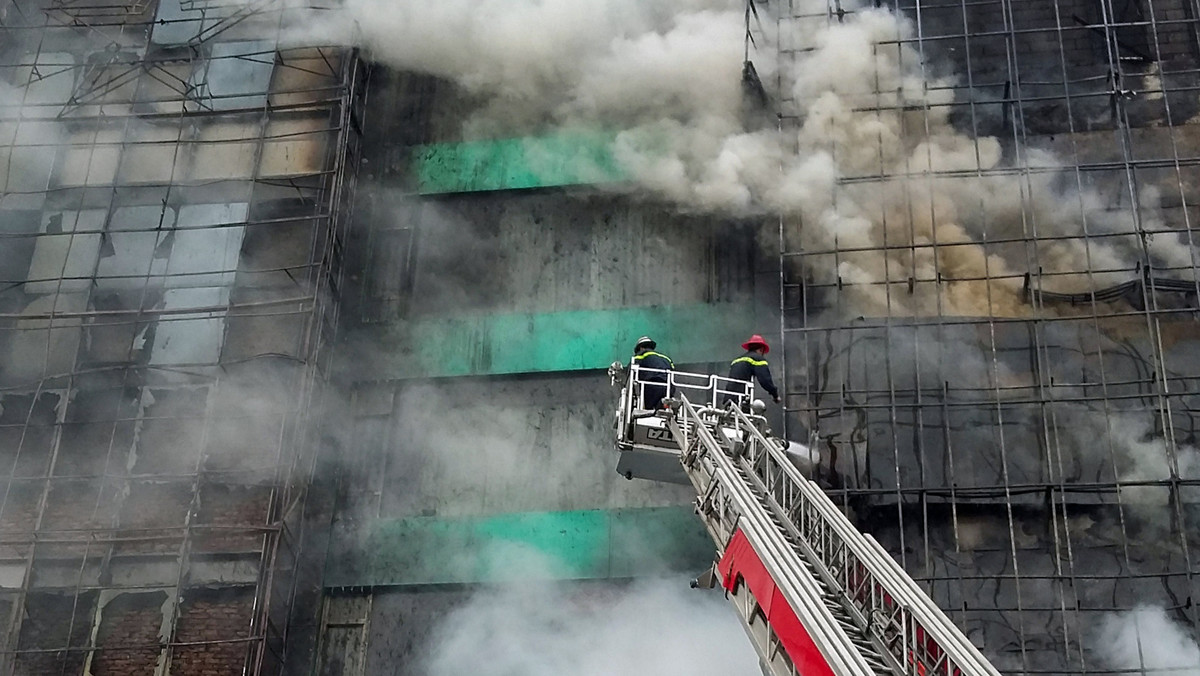 Firefighters work after a fire broke out at a karaoke lounge in Hanoi