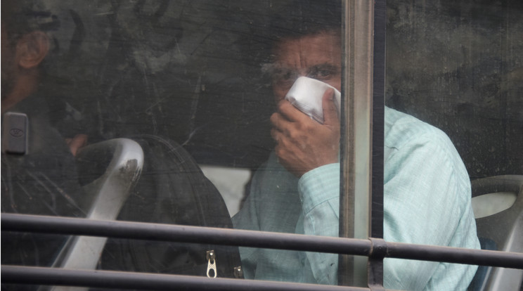 Egy indiai férfi orrát és száját takarja a buszon terjengő bűz miatt, szinte mindennapos jelenet az országban /Fotó: AFP