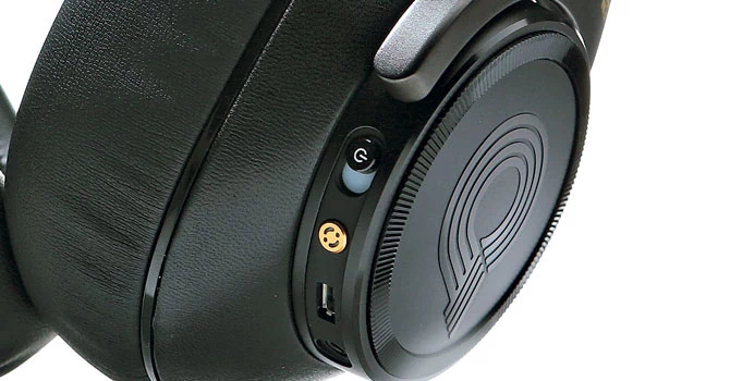Dłuższe naciśnięcie na złotym przycisku uruchamia procedurę pomiarową, a krótkie naciśnięcie to zmiana pomiędzy trybami Standard i Studio z lepszym efektem stereo oraz Surround z rozproszonym dźwiękiem.