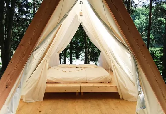 Urokliwe domki jak namioty w środku lasu. Chcemy na taki kemping!
