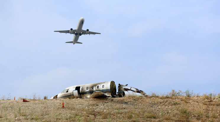 A magánrepülő (lent) túlfutott a pályán, kigyulladt és kettétört /Fotó: AFP
