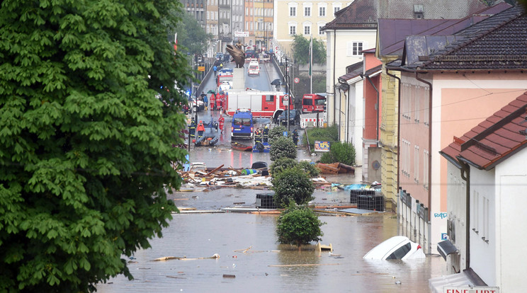 Az árhullám lerombolt házakat, fatörzseket és autókat sodor magával