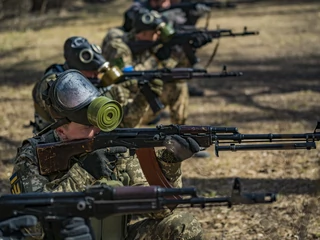 Konflikt wojenny w Ukrainie spowodował większe zainteresowanie bronią i szkoleniami jak się nią posługiwać. Na zdj. Cywilni ochotnicy z chemicznymi maskami przeciwgazowymi uczą się strzelać z karabinów podczas szkolenia wojskowego w lasach Zaporoża w Ukrainie