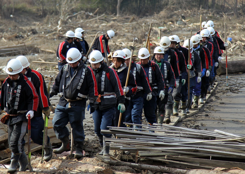 Grupa strażaków poszukuje zaginionych po trzęsieniu ziemi w Japonii w miejscowości Rikuzentakada, prefektura Iwate.