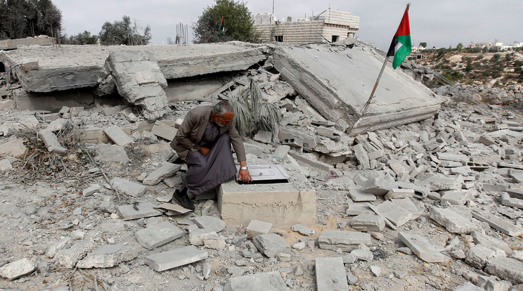 Palesztin férfi az izraeli hadsereg által lerombolt háza romjain / Fotó: AFP